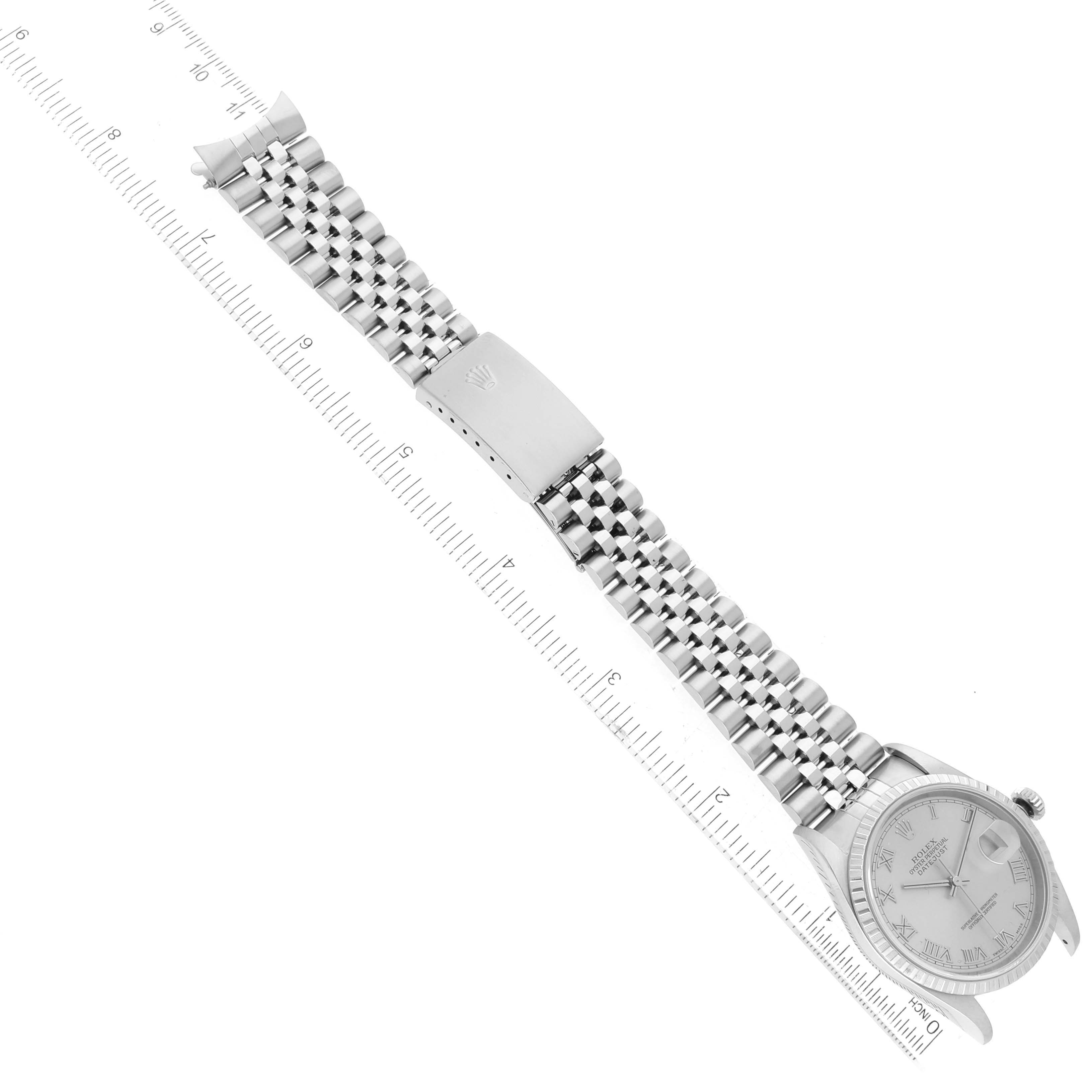The image shows a Rolex Datejust 16220 Men's Stainless Steel Silver Dial 16220 Men's Stainless Steel Silver Dial watch lying flat with a focus on its bracelet and clasp, positioned alongside a ruler.
