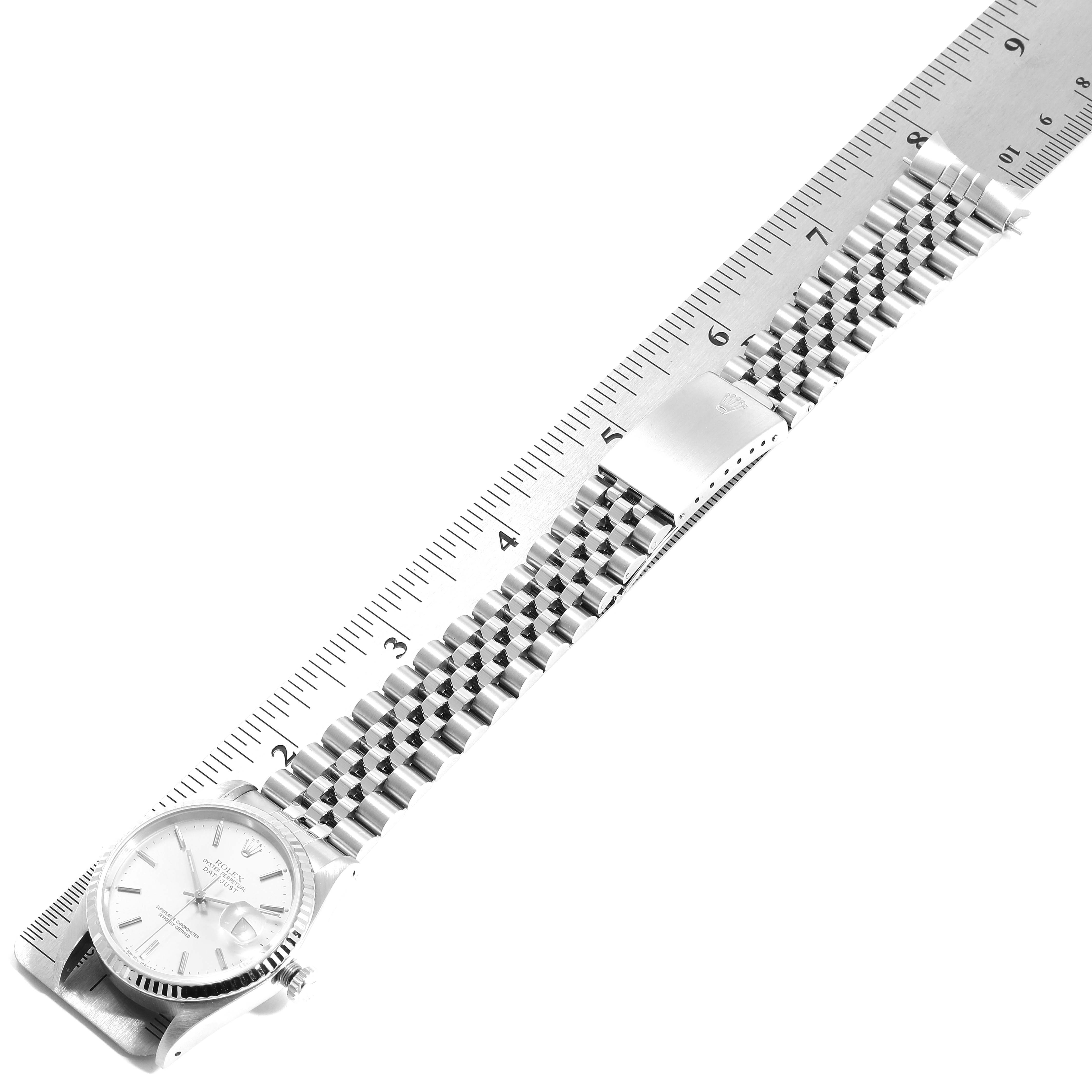 The image shows a Rolex Datejust 16234 Men's Stainless Steel Silver Dial 16234 Men's Stainless Steel Silver Dial watch laid flat with a ruler beside it, displaying the face, bracelet, and clasp.