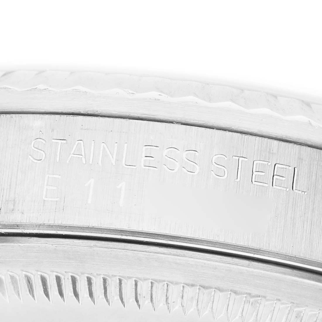 The image shows a close-up of the stainless steel back casing with text of a Rolex Datejust 16234 Men's Stainless Steel Silver Dial watch.