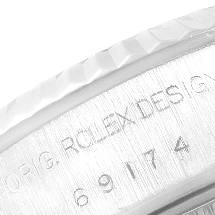 The image shows an angled close-up of the engraved inner bezel of a Rolex Datejust 69174 Women
s Stainless Steel Silver Dial 69174 Women
s Stainless Steel Silver Dial watch.