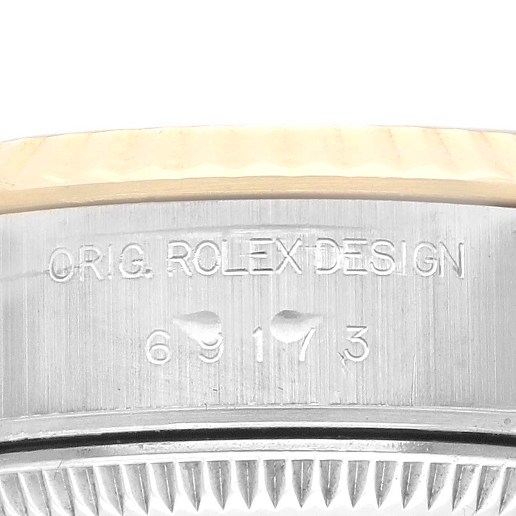 The image shows a close-up of the side of a Rolex Datejust 69173 Women
s Steel and Gold (two tone) Black Dial 69173 Women
s Steel and Gold (two tone) Black Dial, focusing on the engraved serial and design numbers.
