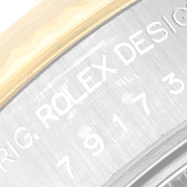 The image shows a close-up of the side engraving on the case back of a Rolex Datejust 79173 Women's Steel and Gold (two tone) Black Dial 79173 Women's Steel and Gold (two tone) Black Dial watch.