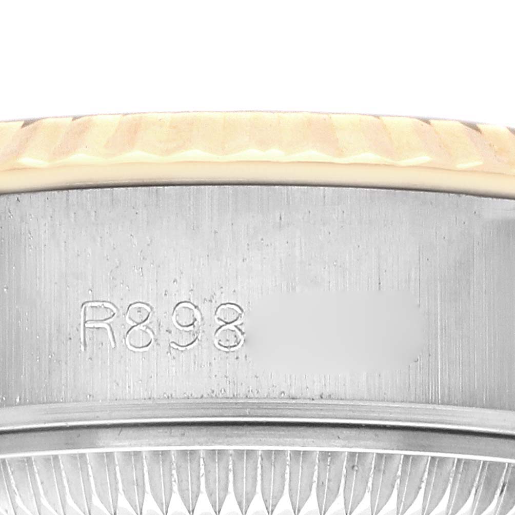 The image shows a close-up of the side view of a Rolex Datejust 69173 Women
s Steel and Gold (two tone) Champagne Dial 69173 Women
s Steel and Gold (two tone) Champagne Dial, highlighting the edge of the bezel with some engraved markings.