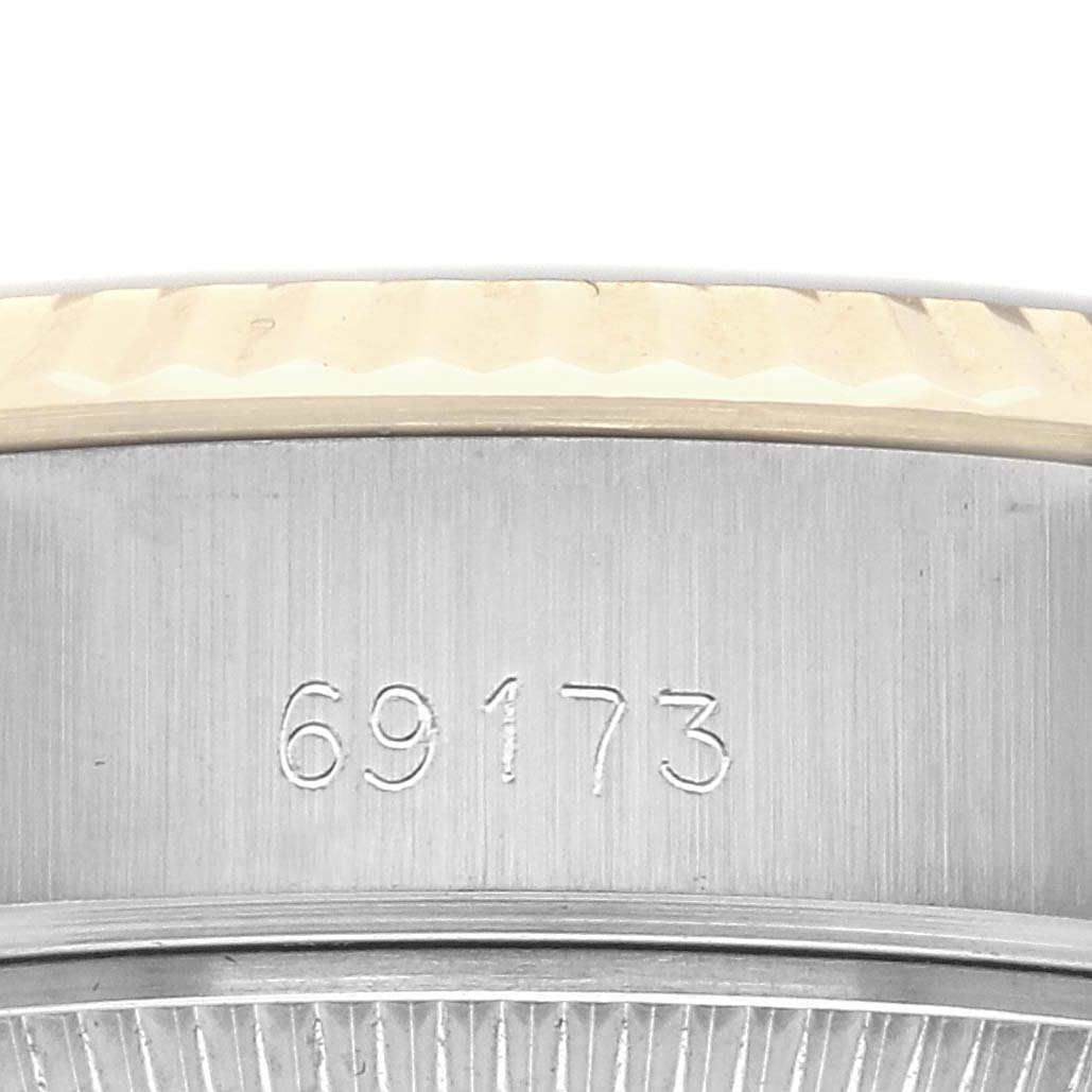 The image shows a close-up of the Rolex Datejust 69173 Women
s Steel and Gold (two tone) Champagne Dial 69173 Women
s Steel and Gold (two tone) Champagne Dial
s side, displaying its serial number and part of the fluted bezel.