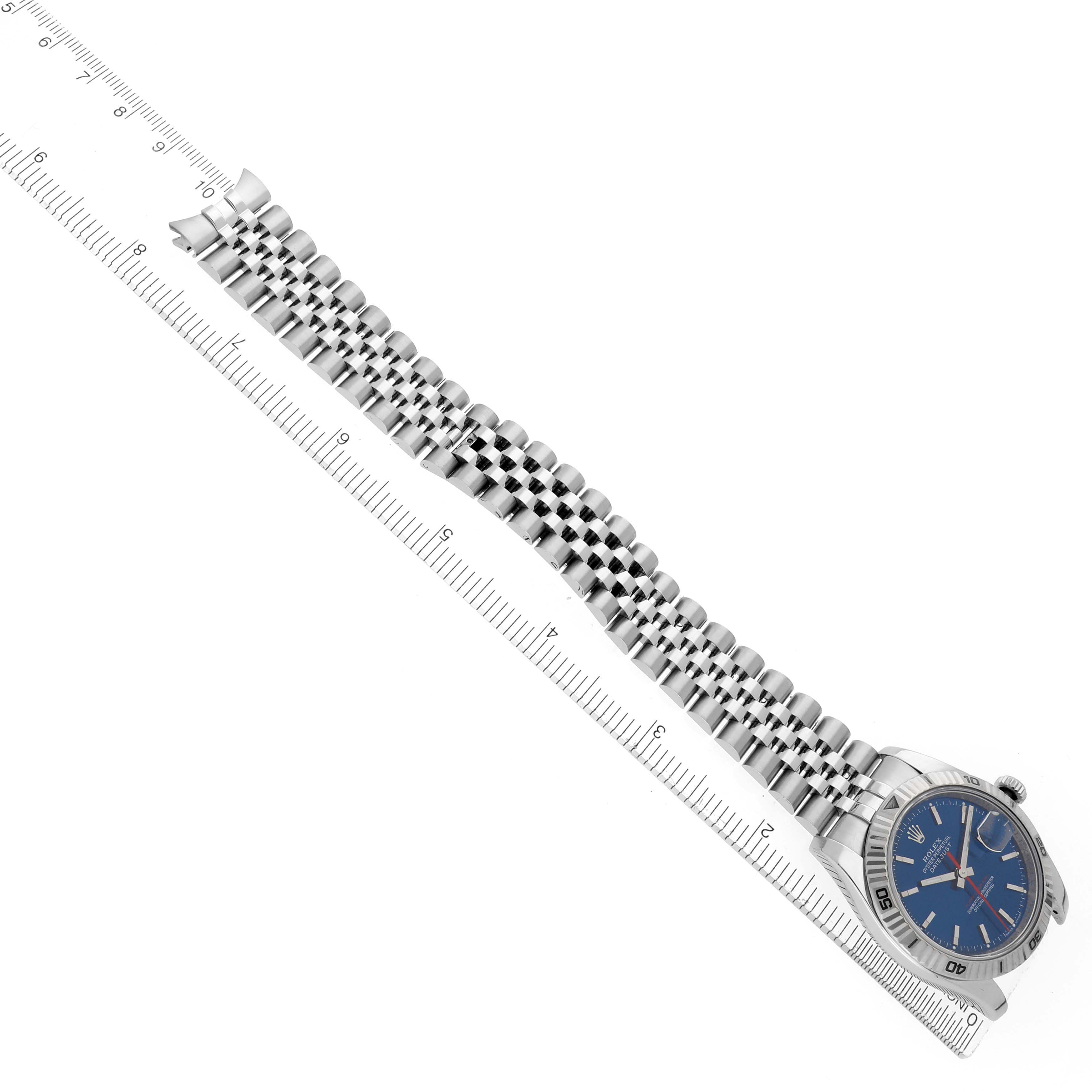 The Rolex Turn-o-Graph 116264 Men
s Stainless Steel Blue Dial 116264 Men
s Stainless Steel Blue Dial watch is shown at a side angle, highlighting the bracelet, bezel, and face alongside a ruler.