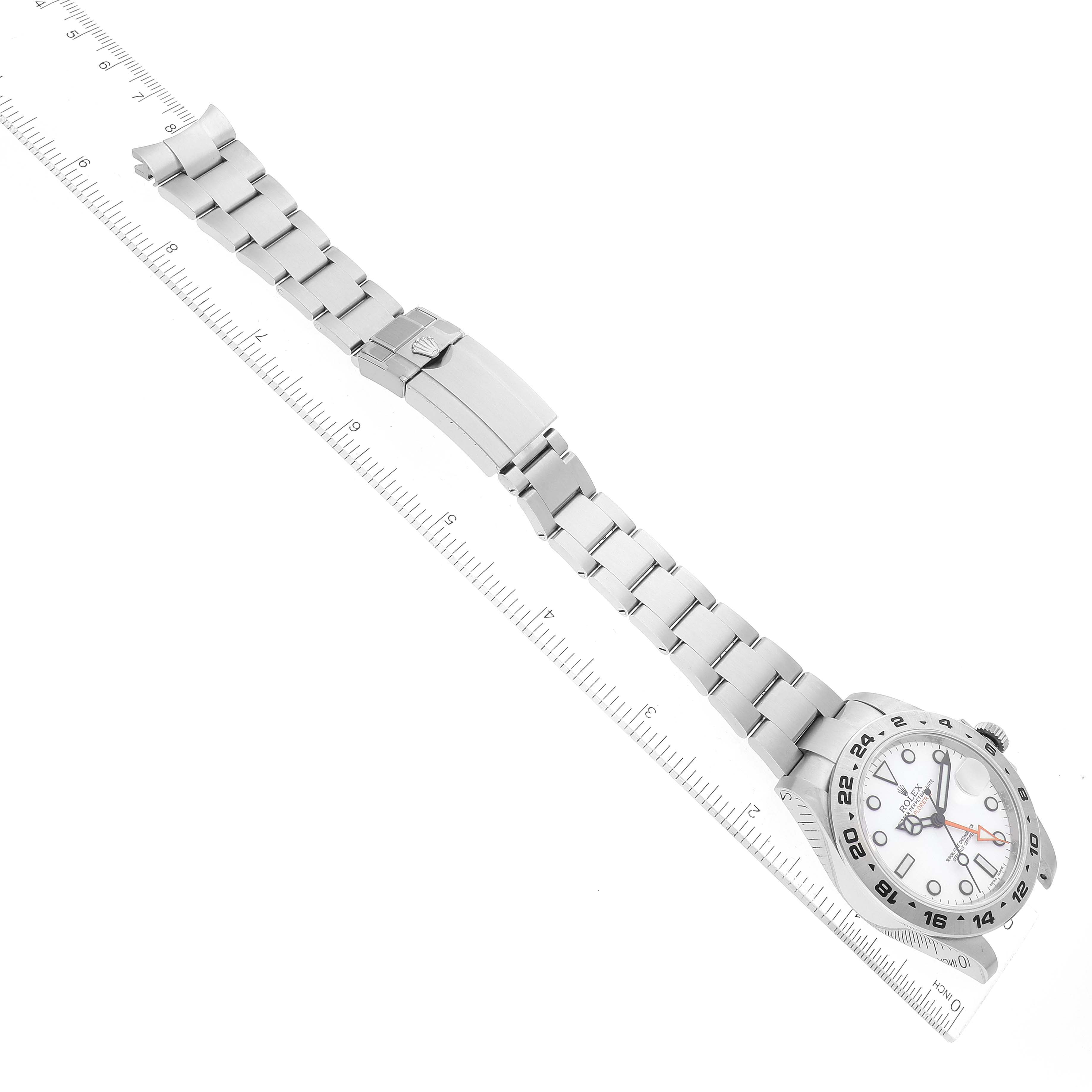 This image shows a top-down view of the Rolex Explorer 216570 Men
s Stainless Steel White Dial 216570 Men
s Stainless Steel White Dial watch, featuring its dial, bracelet, and clasp next to a ruler.