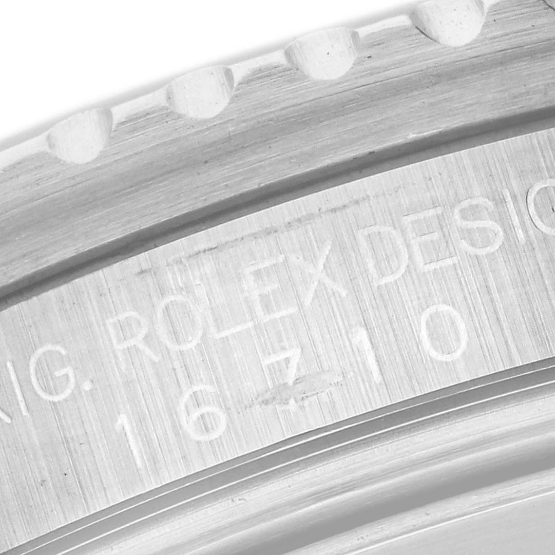 This image shows an engraved close-up of the GMT-Master model by Rolex, highlighting the serial number and part of the bezel.