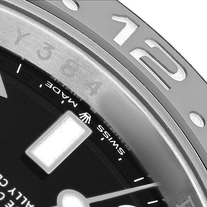 This close-up shows the bezel and part of the dial of a Rolex GMT-Master M126710GRNR Men's Stainless Steel Black Dial with a "12" marker and "Swiss Made" text visible.