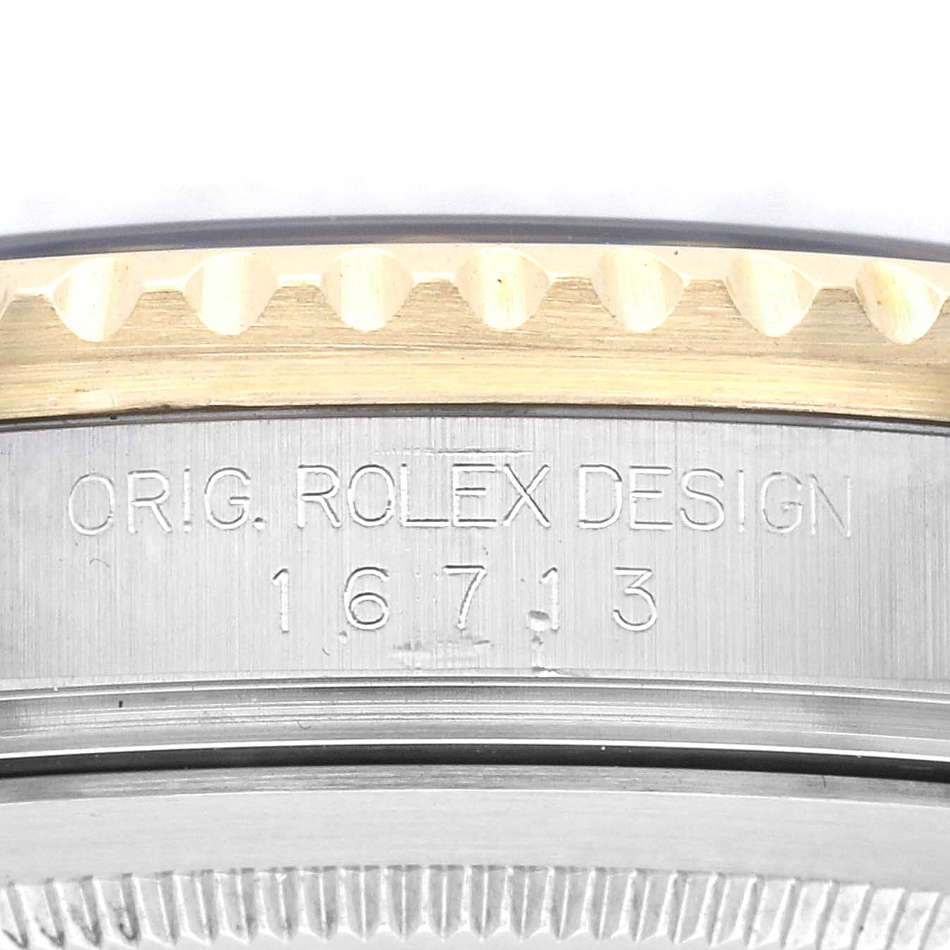 The image shows a close-up of the engraved side of the Rolex GMT-Master 16713 Men
s Steel and Gold (two tone) Black Dial 16713 Men
s Steel and Gold (two tone) Black Dial model 16713, highlighting the model number and part of the bezel.