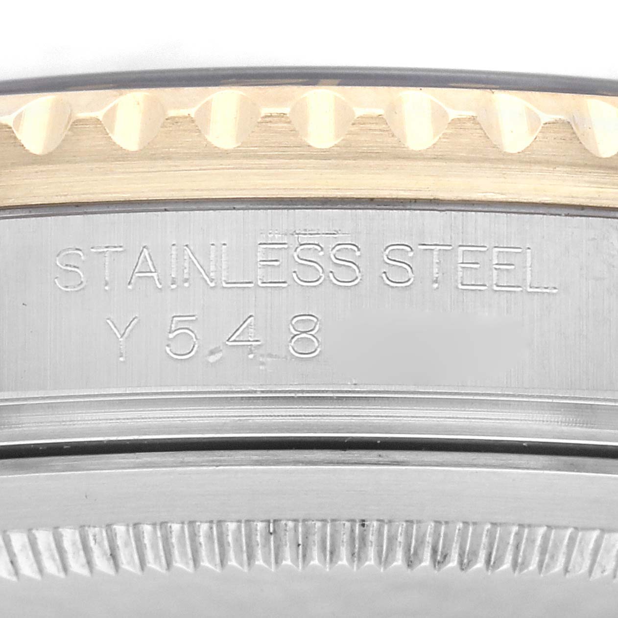 The image shows a close-up of the side of a Rolex GMT-Master 16713 Men
s Steel and Gold (two tone) Black Dial 16713 Men
s Steel and Gold (two tone) Black Dial with engravings, highlighting the stainless steel material.