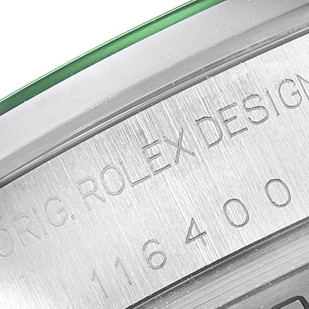 This close-up image shows the engraved side of a Rolex Milgauss 116400V Men
s Stainless Steel Black Dial 116400V Men
s Stainless Steel Black Dial watch case, including part of the bezel and green sapphire crystal edge.