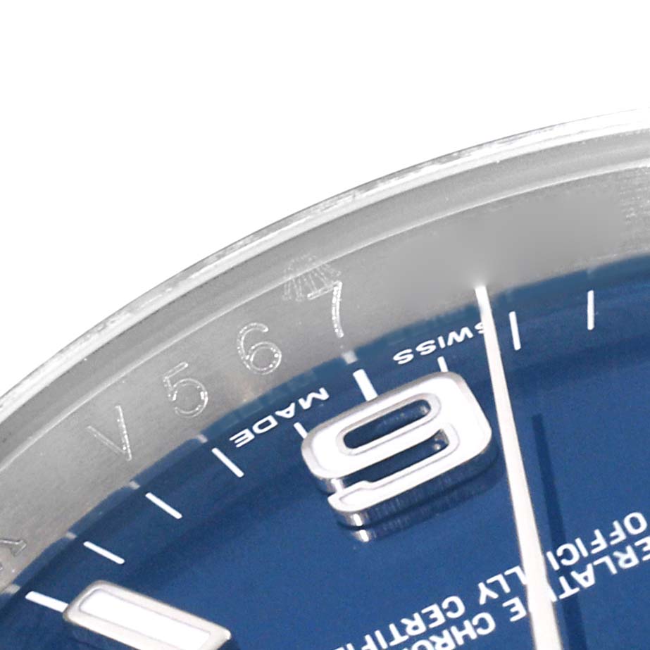 The image shows a close-up of the dial and bezel of the Rolex Oyster Perpetual 116000 Men
s Stainless Steel Blue Dial 116000 Men
s Stainless Steel Blue Dial watch, highlighting the "SWISS MADE" text and part of the 9 o
clock marker.