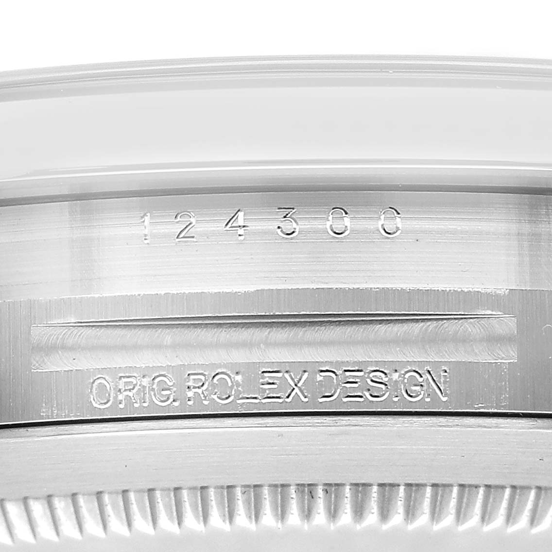 The image shows a close-up of the side of the Rolex Oyster Perpetual 124300 Men's Stainless Steel Blue Dial watch case, revealing engraved model details.