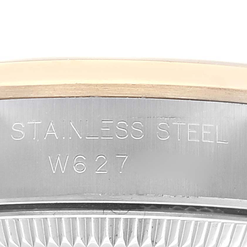 This close-up shows the side of the casing of a Rolex Oyster Perpetual 67183 Women's Steel and Gold (two tone) Grey Dial 67183 Women's Steel and Gold (two tone) Grey Dial watch, highlighting the "STAINLESS STEEL" engraving and partial serial number.