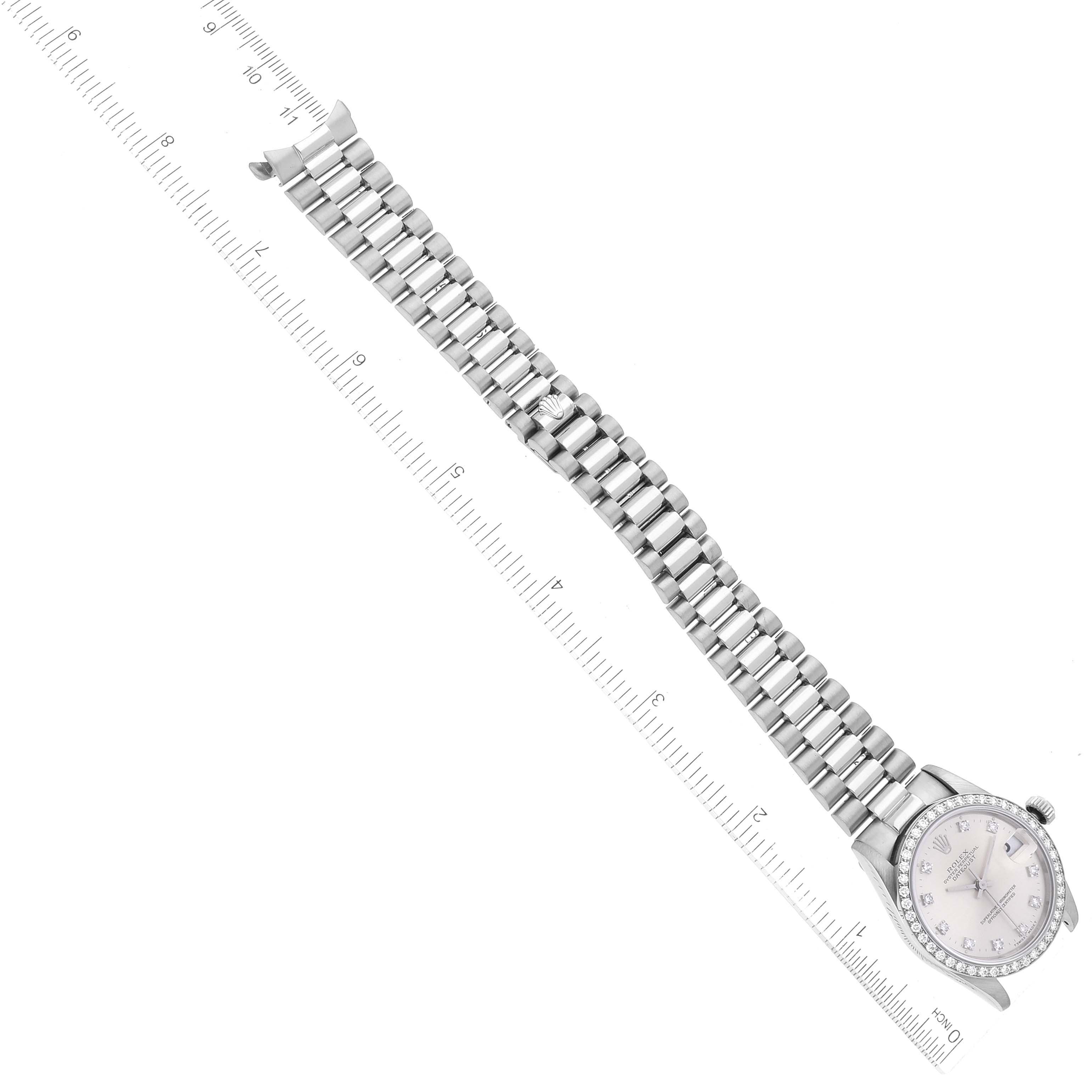 The image shows a top-down view of a Rolex President 68289 Women's White Gold Silver Dial 68289 Women's White Gold Silver Dial model watch, displaying the face, bezel, and bracelet alongside a ruler.