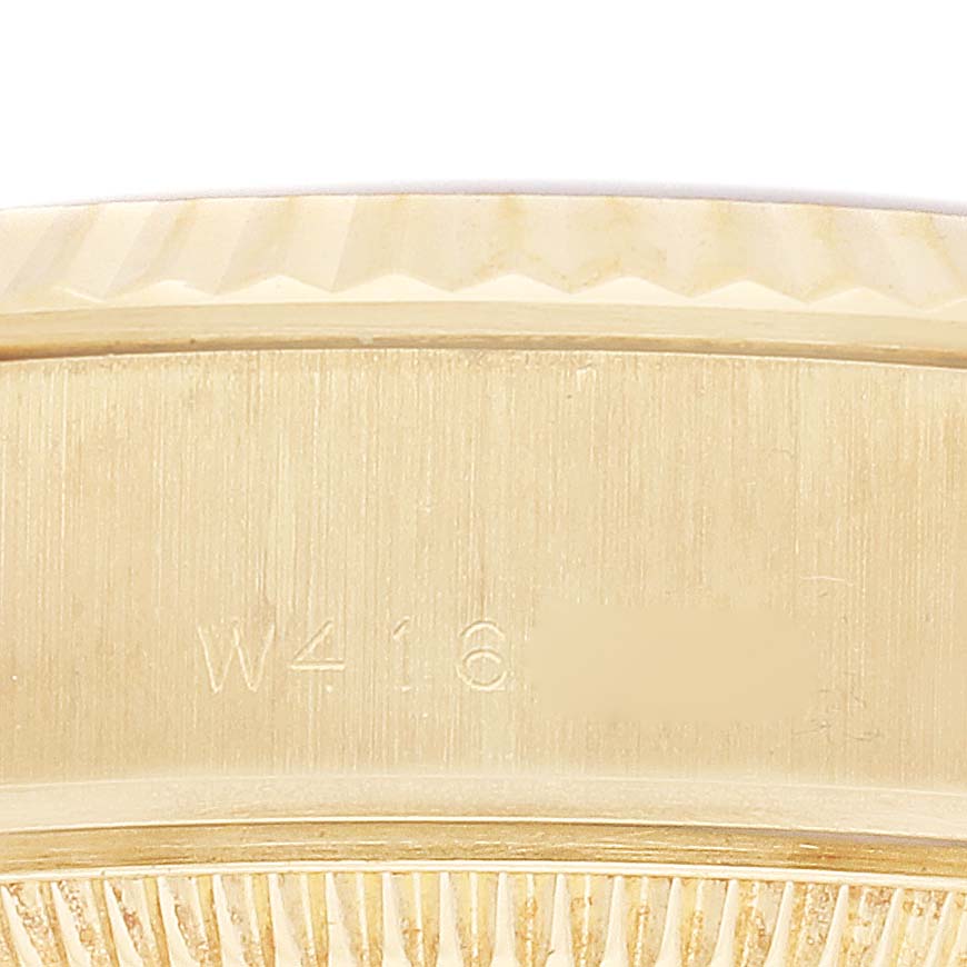The image shows a close-up of the edge and case back of a Rolex President 69178 Women
s Yellow Gold Champagne Dial 69178 Women
s Yellow Gold Champagne Dial model watch, highlighting the serial number engraving.