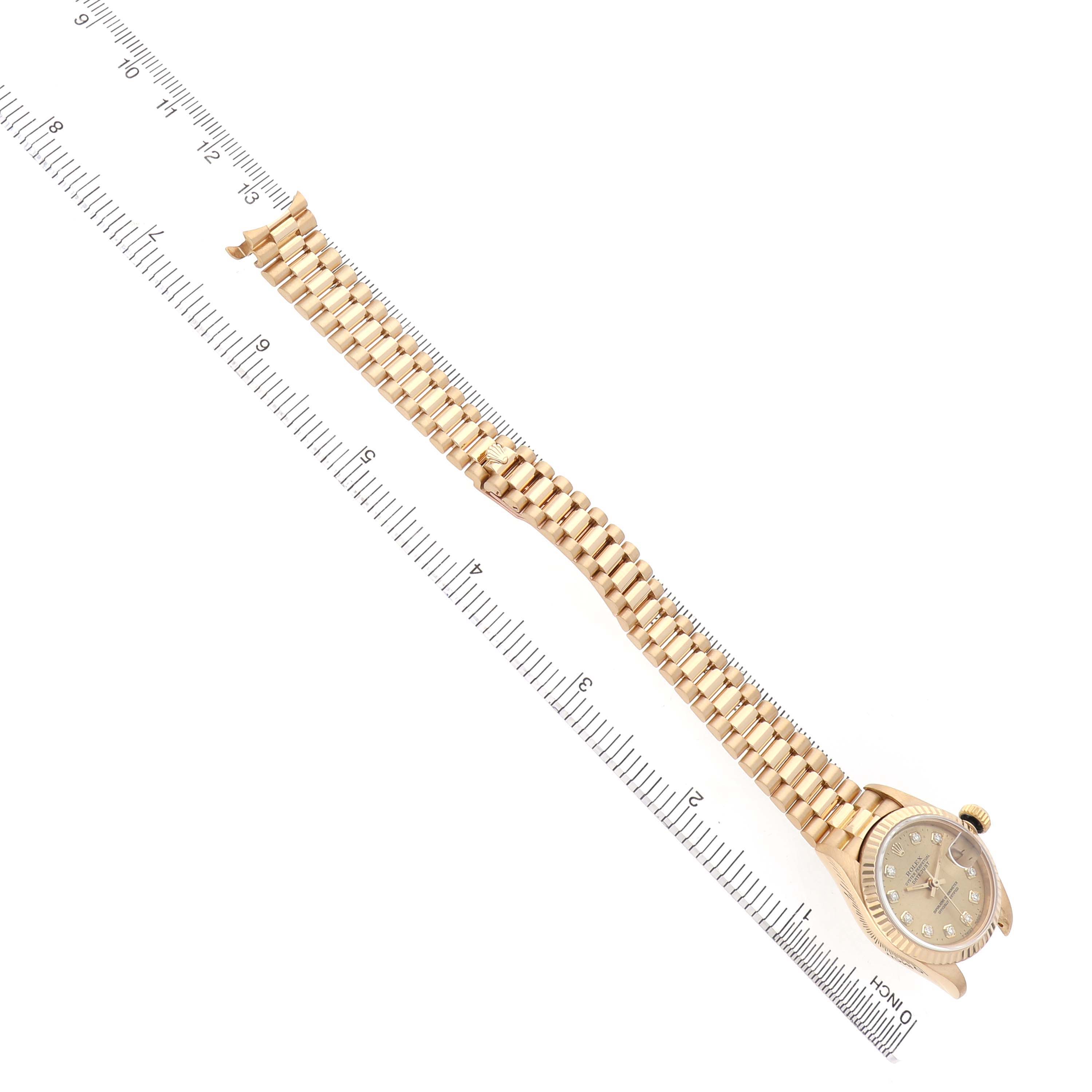 The Rolex President 69178 Women's Yellow Gold Champagne Dial model watch is shown from a top-down angle, displaying its full bracelet and dial alongside a ruler for scale.