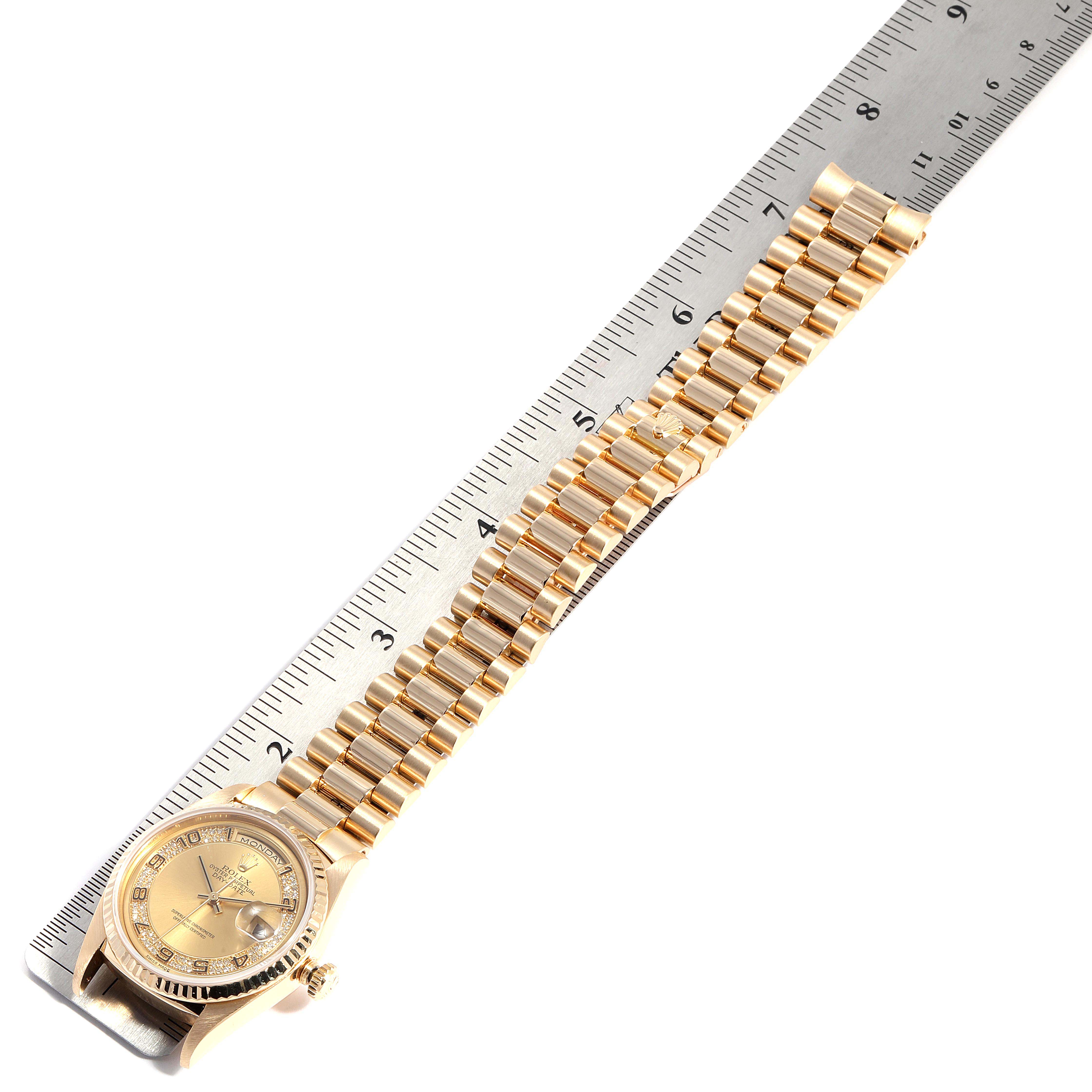 The image shows a Rolex President 18388 Men
s Yellow Gold Champagne Dial 18388 Men
s Yellow Gold Champagne Dial model watch laid flat next to a ruler, displaying the watch face and bracelet.