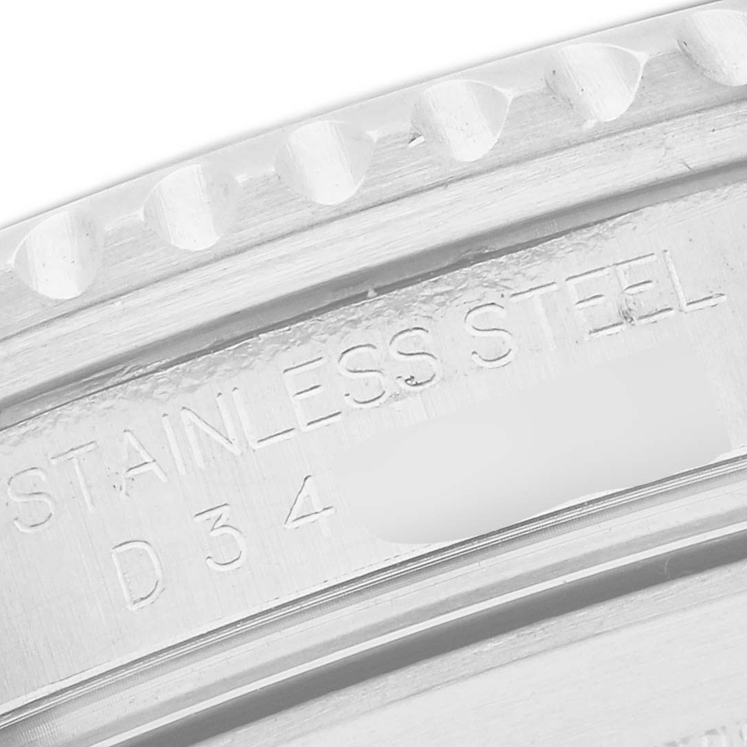 The image shows a close-up of the engraving on the bezel edge of a Rolex Submariner 16610 Men
s Stainless Steel Black Dial 16610 Men
s Stainless Steel Black Dial, highlighting "STAINLESS STEEL" text.