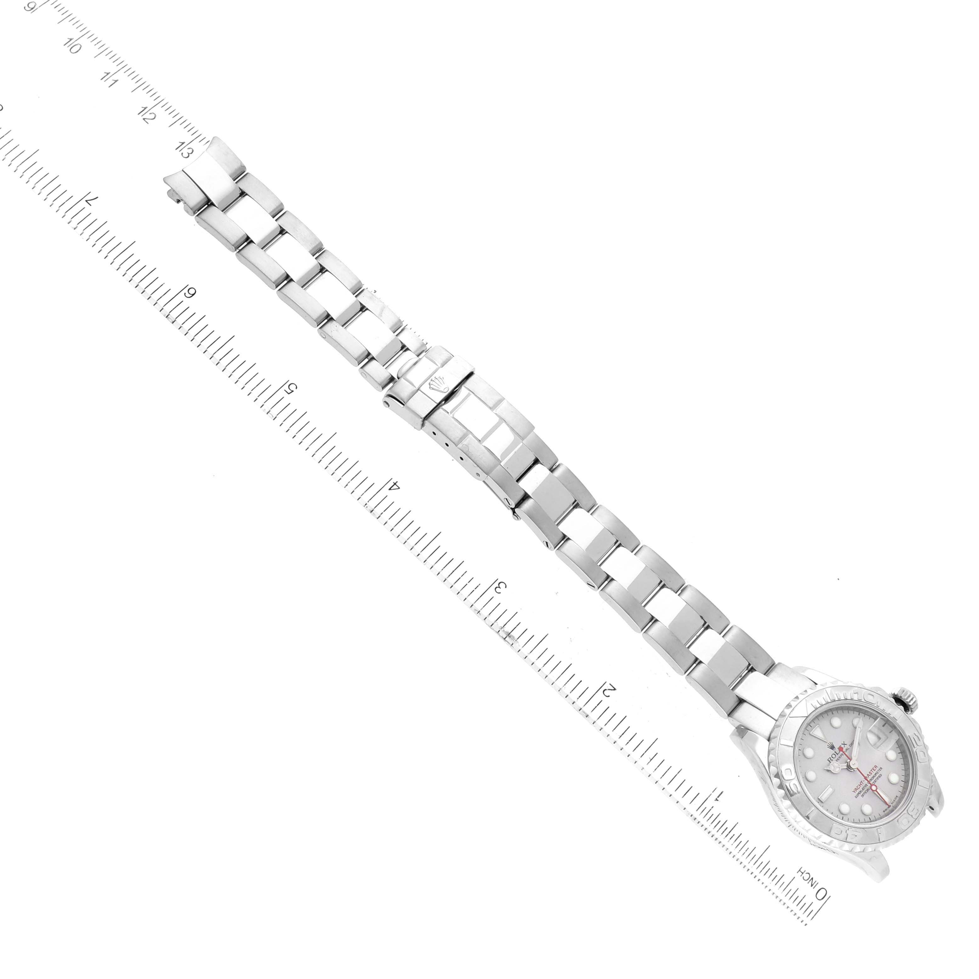 The image shows a Rolex Yacht-Master 169622 Women
s Stainless Steel Silver Dial 169622 Women
s Stainless Steel Silver Dial watch laid flat, displaying the bracelet, clasp, and dial next to a ruler.