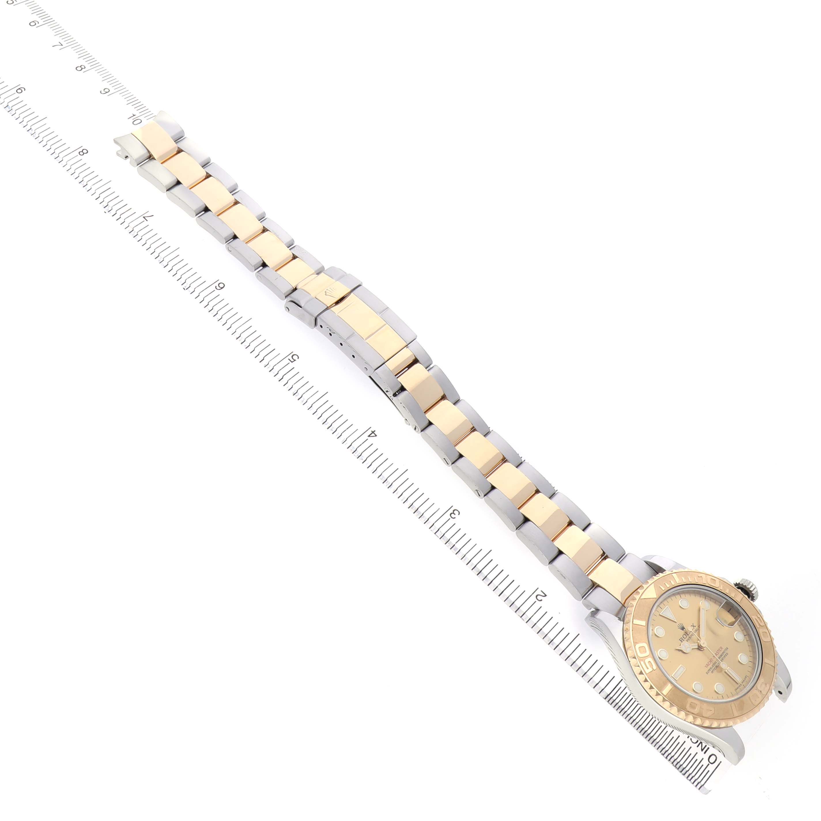 The Rolex Yacht-Master 168623 Men's Steel and Gold (two tone) Champagne Dial watch is shown from an overhead angle, displaying its full bracelet and face alongside a ruler for scale.