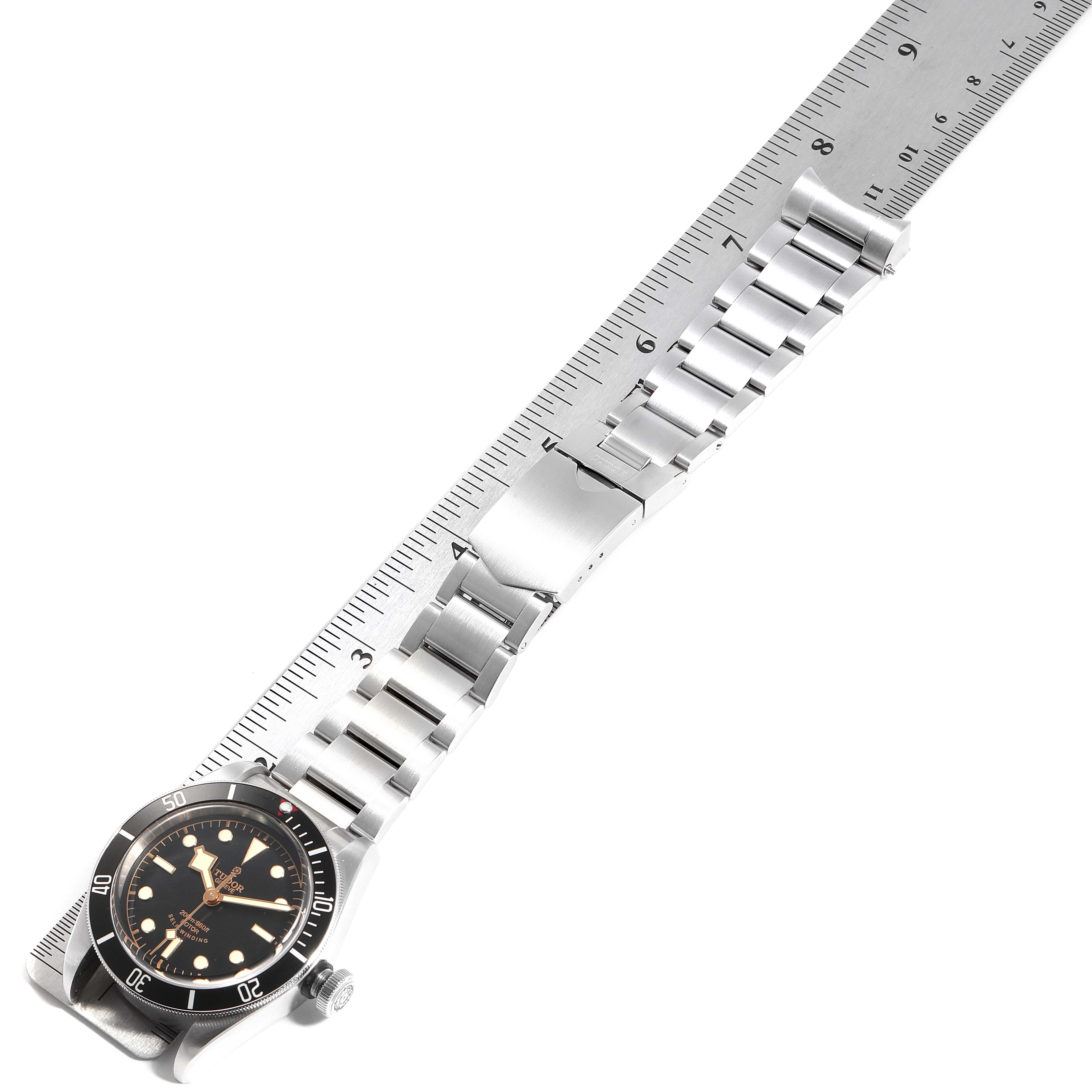 The image shows a Tudor Heritage Black Bay 79220R Men
s Stainless Steel Black Dial 79220R Men
s Stainless Steel Black Dial watch laid flat with its stainless steel bracelet and clasp fully visible.