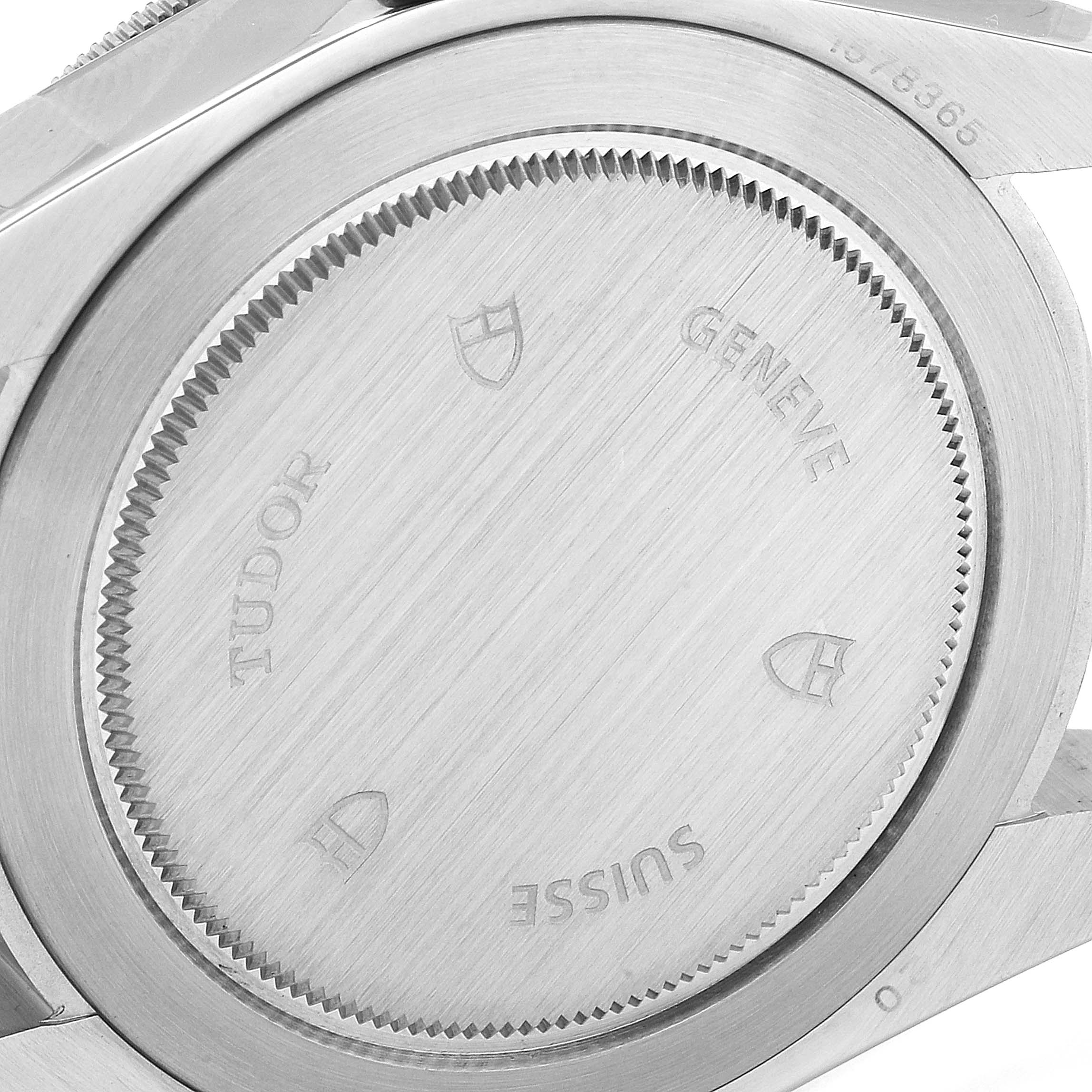 The image shows the back case of a Tudor Heritage Black Bay 79220R Men
s Stainless Steel Black Dial 79220R Men
s Stainless Steel Black Dial watch with engravings and a brushed metal finish.