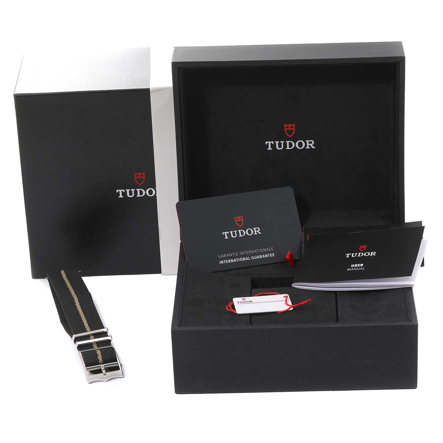 The Tudor Heritage Black Bay 79833MN Men's Stainless Steel Black Dial 79833MN Men's Stainless Steel Black Dial watch set includes the outer box, inner box, strap, guarantee card, and user manual presented from a front angle.