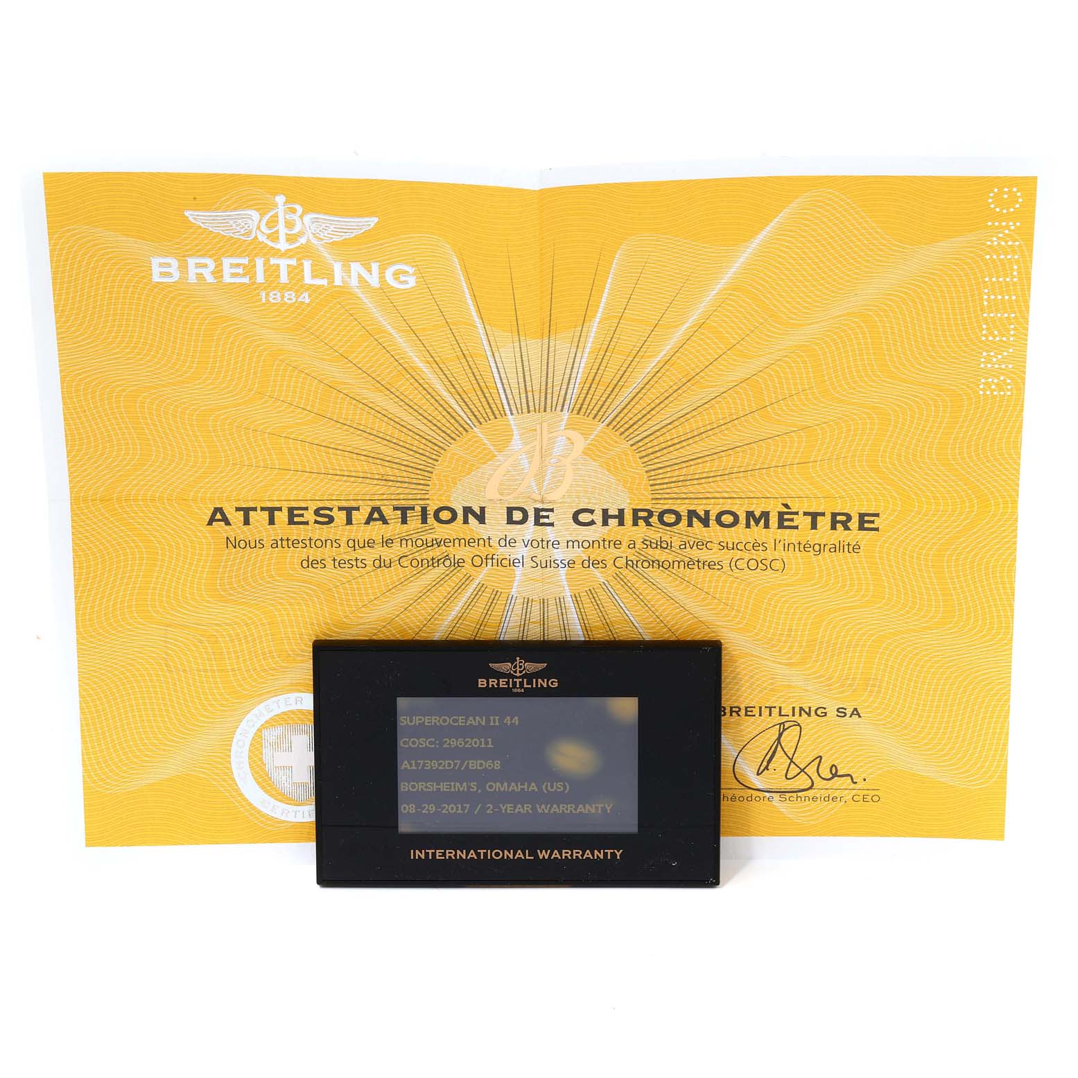 The image shows a Breitling Superocean A17392D8/C910 Men
s Stainless Steel Black Dial A17392D8/C910 Men
s Stainless Steel Black Dial model
s international warranty card and chronometer certificate on a yellow background.
