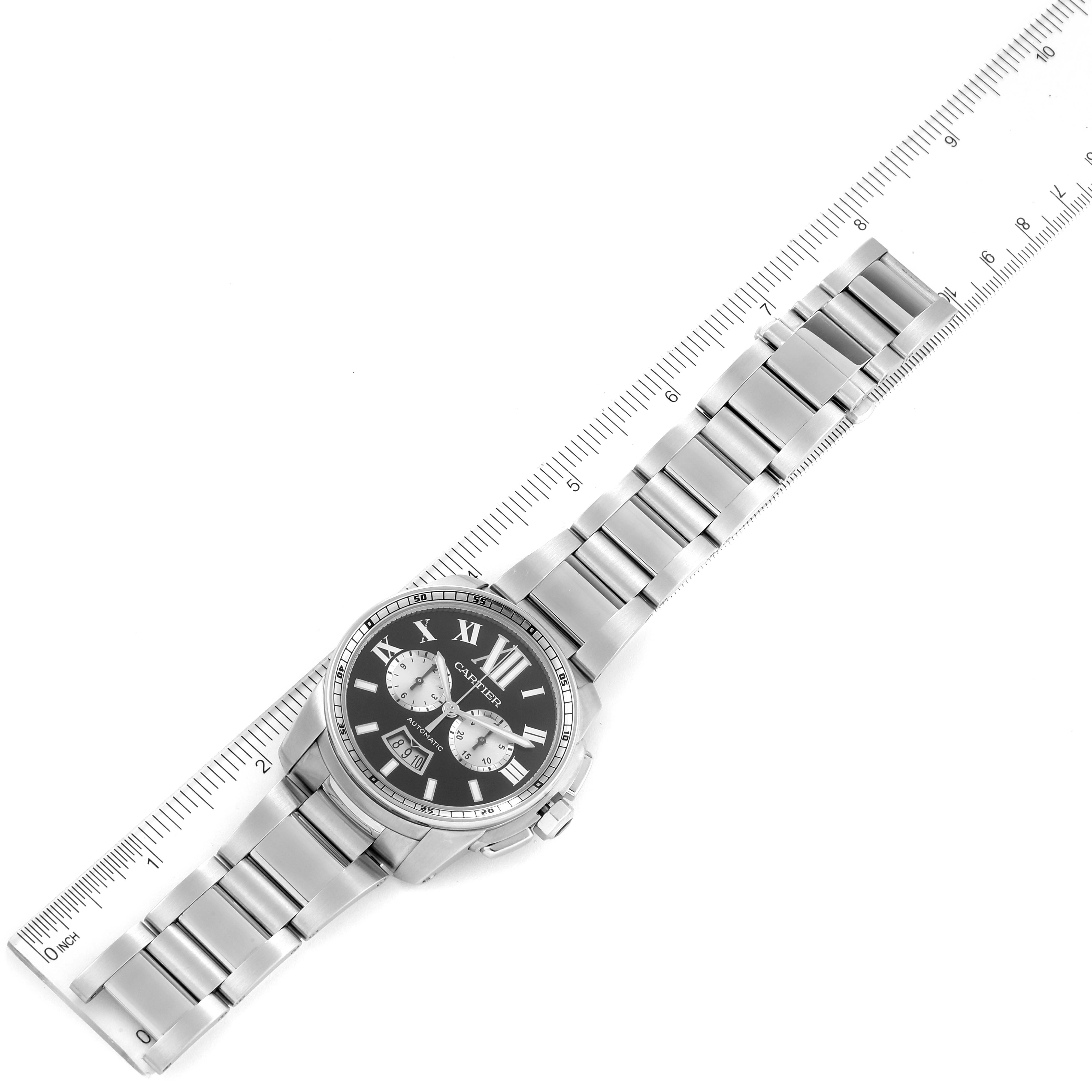 This image shows a full view of the Calibre de Cartier watch by Cartier from a top-down angle, displayed with a ruler for scale.