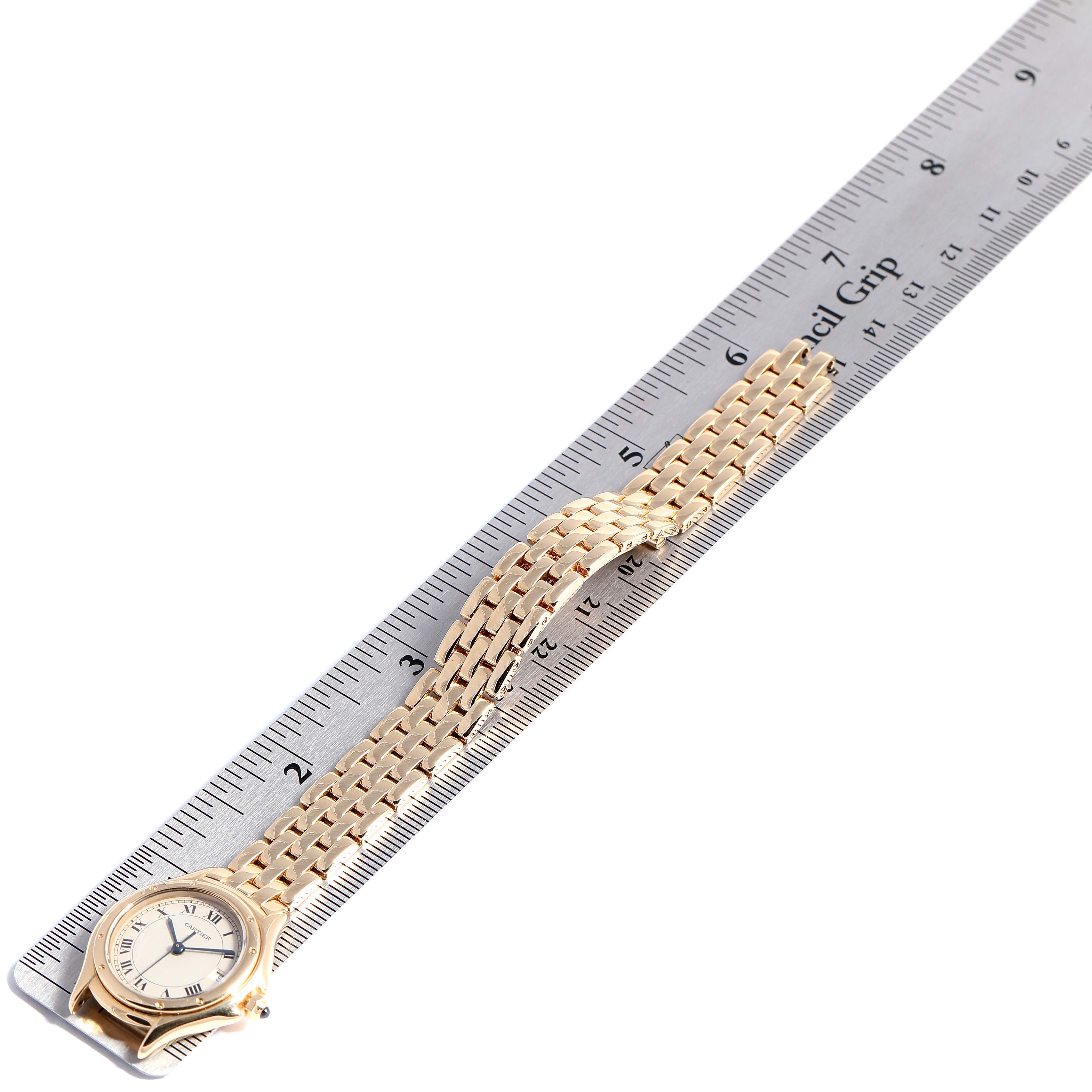 This image shows a Cartier Panthere 887906 Women's Yellow Gold Silver Dial 887906 Women's Yellow Gold Silver Dial watch laid flat alongside a ruler, highlighting its length and gold bracelet.