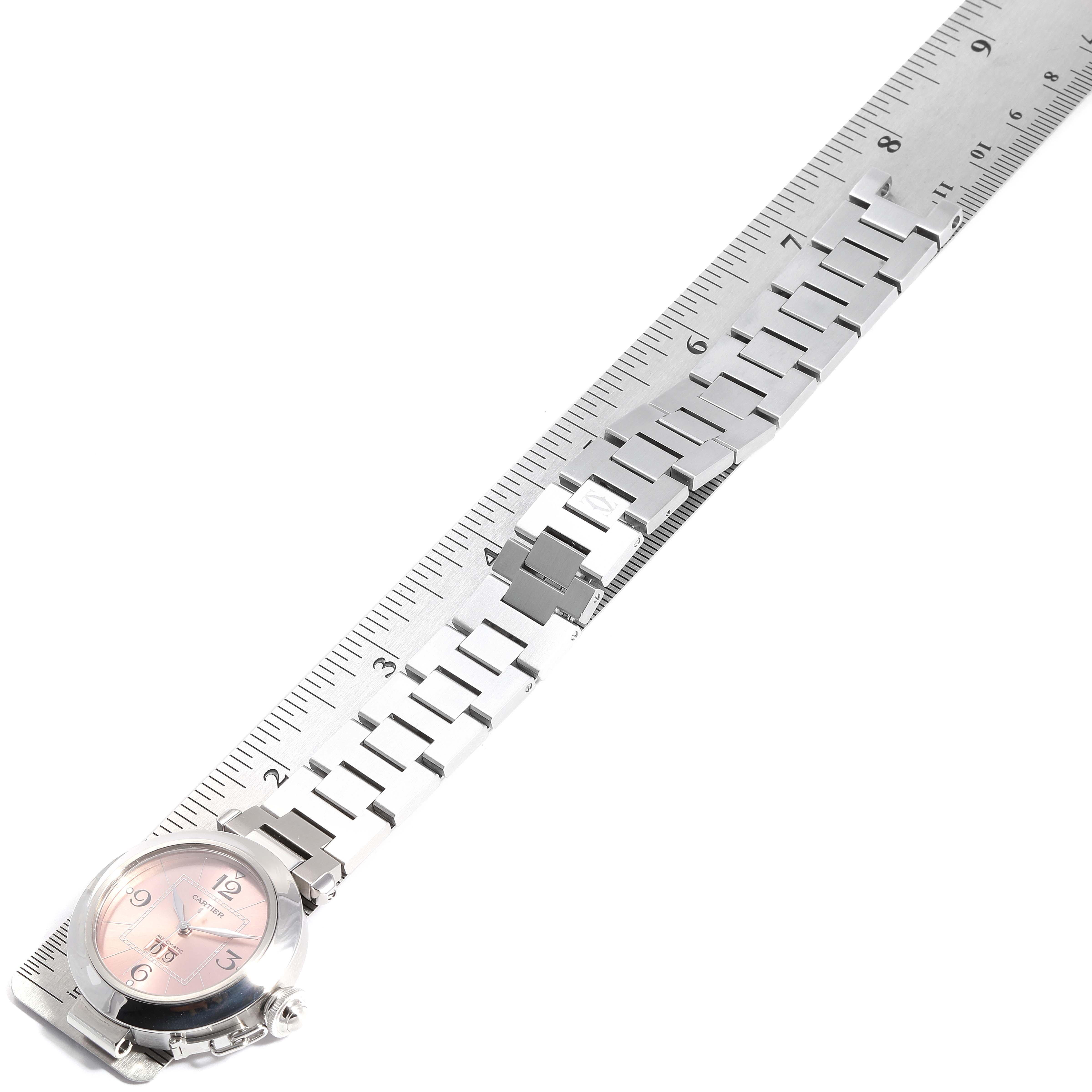 The image shows a Cartier Pasha W31058M7 Women's Stainless Steel Pink Dial W31058M7 Women's Stainless Steel Pink Dial watch at a top-down angle, highlighting the dial and metal bracelet alongside a ruler.