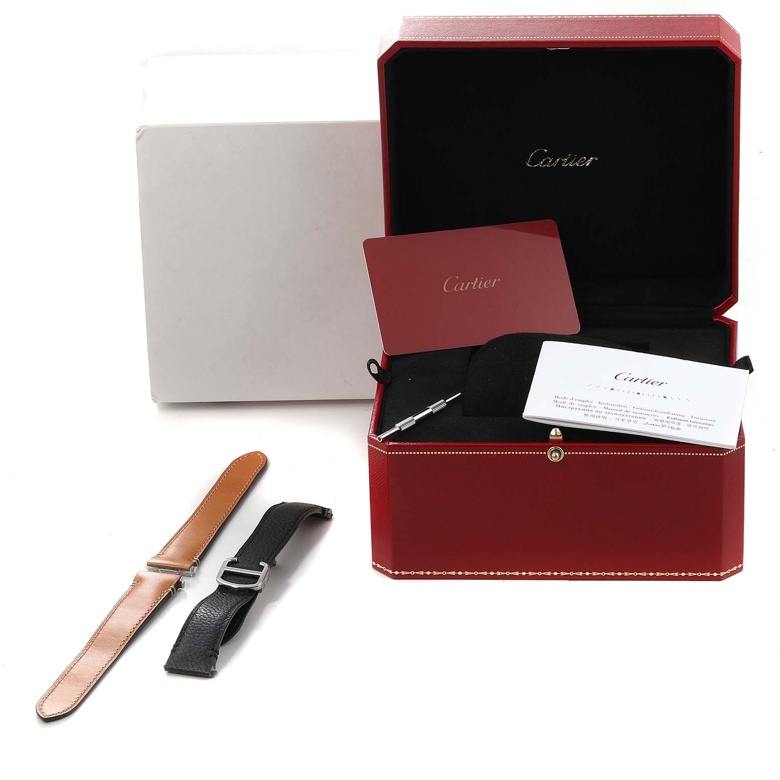 The image shows a Cartier Santos WSSA0010 Men's Stainless Steel Silver Dial WSSA0010 Men's Stainless Steel Silver Dial watch box, extra watch straps, a screwdriver, and documentation from a slightly elevated angle.