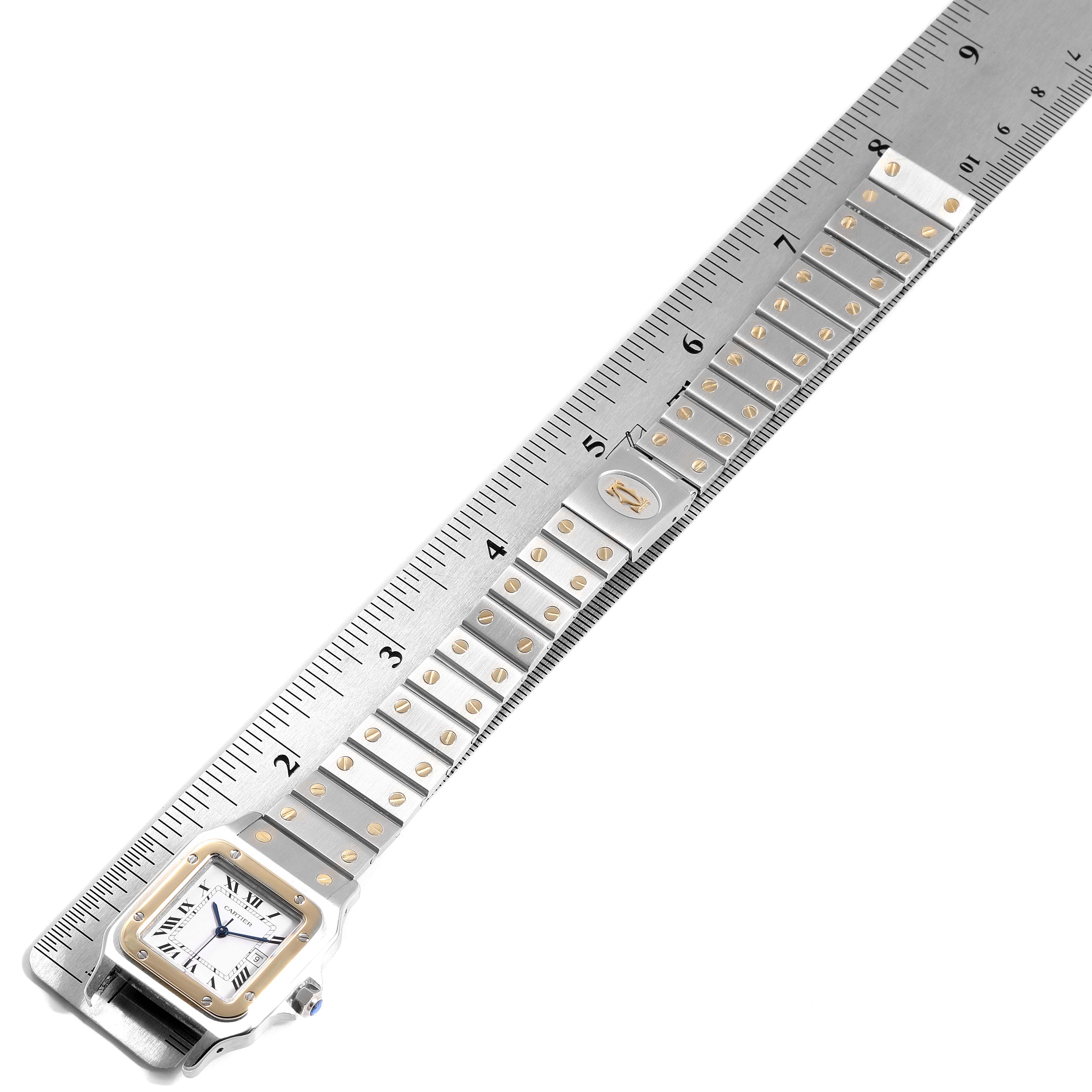 The image shows the Santos watch by Cartier with the face and full length of the band aligned next to a ruler.