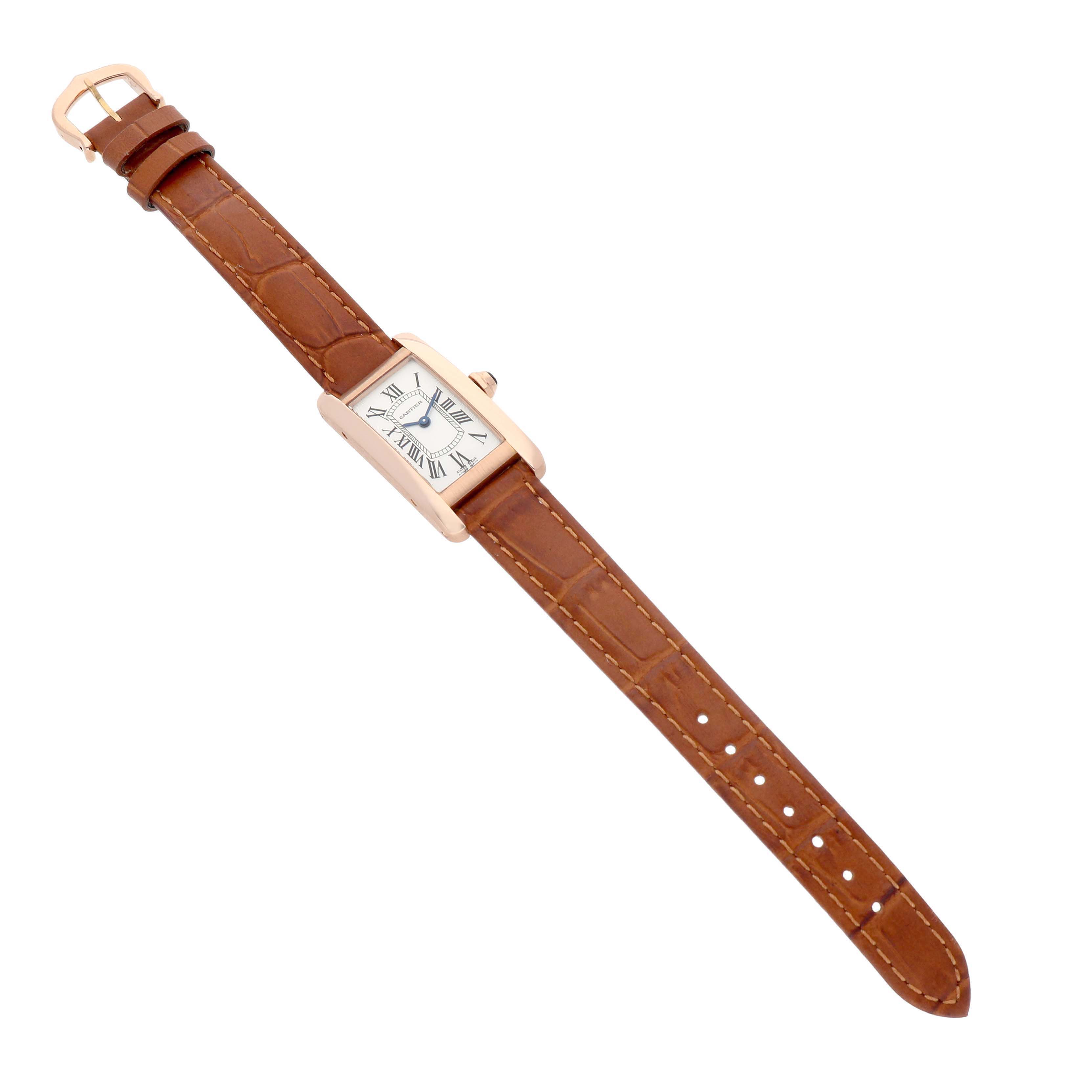 The Cartier Tank Americaine W2607456 Women's Rose Gold White Dial watch is shown at a slight angle, highlighting its rectangular case, brown leather strap, and classic Roman numeral dial.