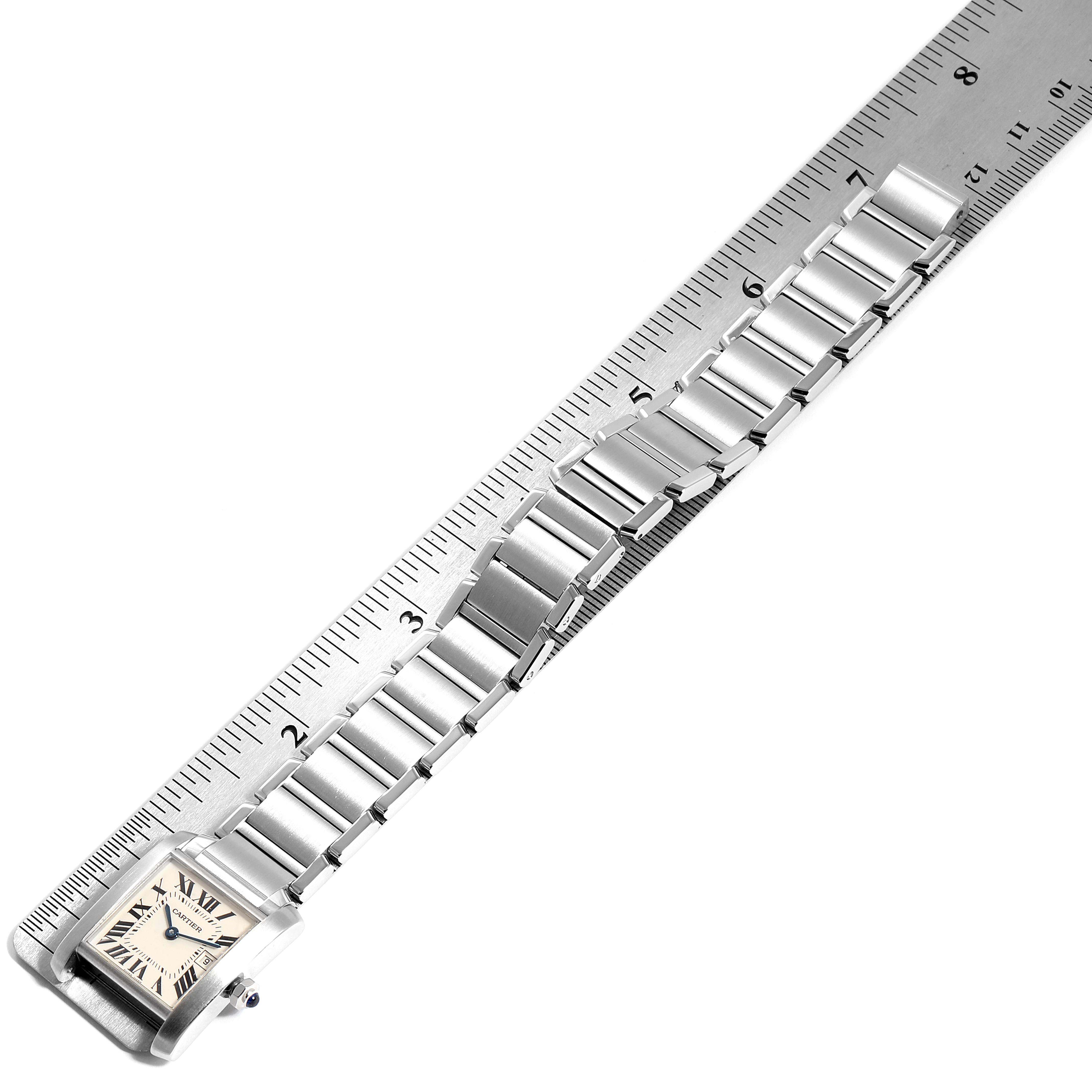 The Cartier Tank Francaise W51011Q3 Women
s Stainless Steel Silver Dial W51011Q3 Women
s Stainless Steel Silver Dial watch is shown from an overhead angle, highlighting its face and full metal band against a ruler for scale.