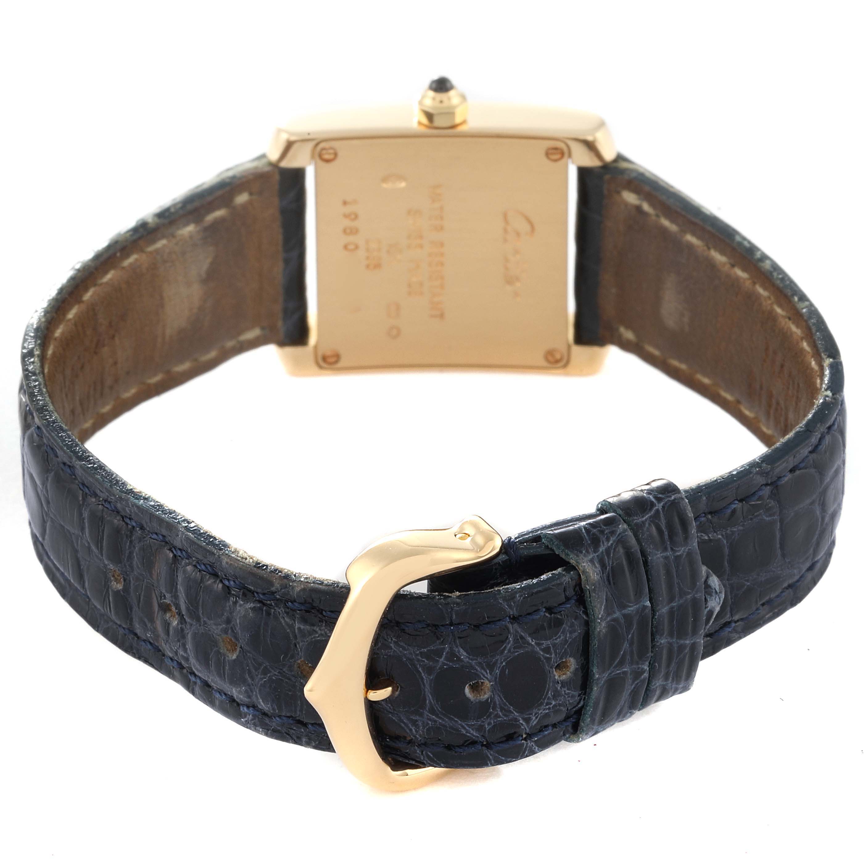 The image shows the back of a Cartier Tank Française watch, featuring its case back and leather strap with a gold buckle.