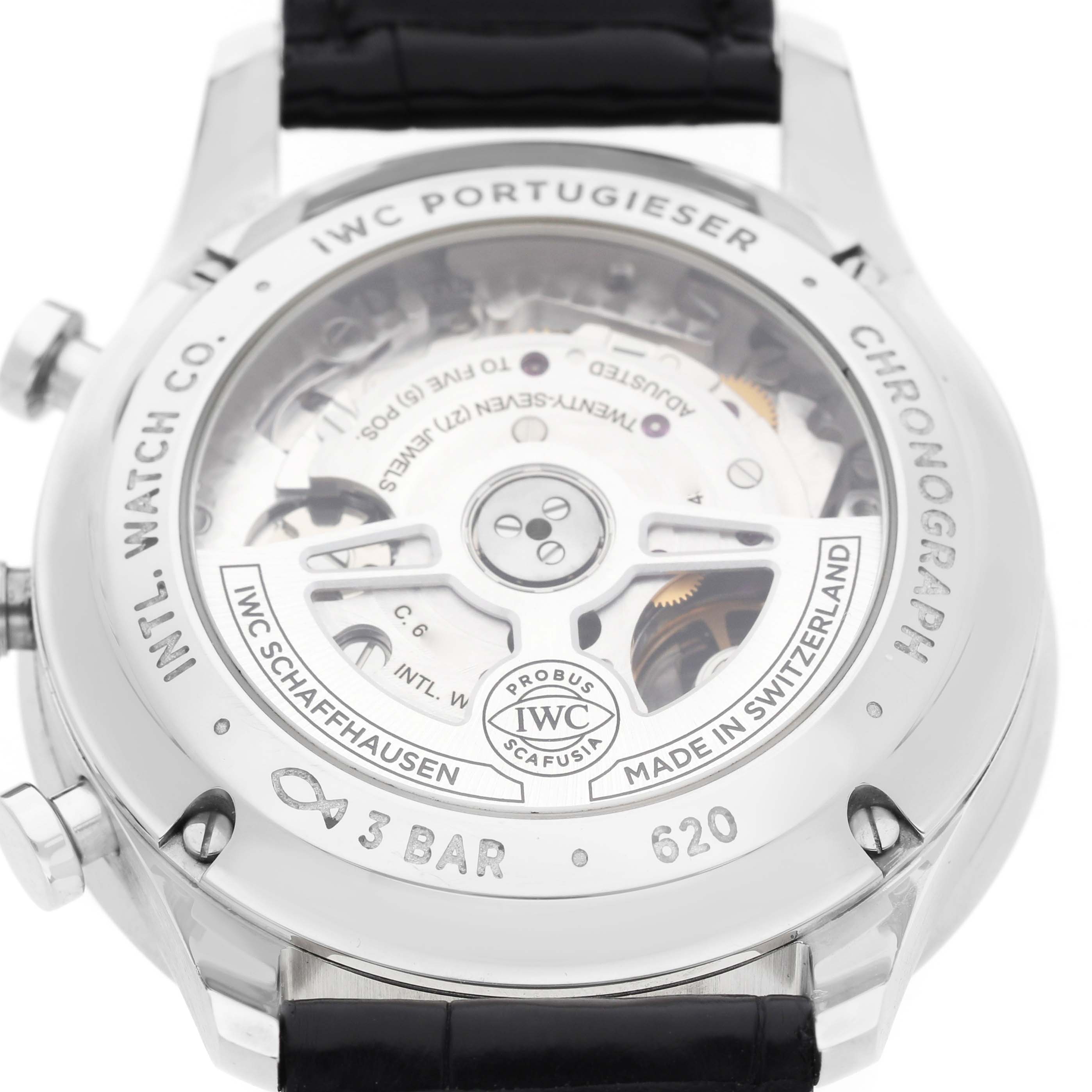 The image shows the back of the IWC Portugieser watch, highlighting its movement and engravings.