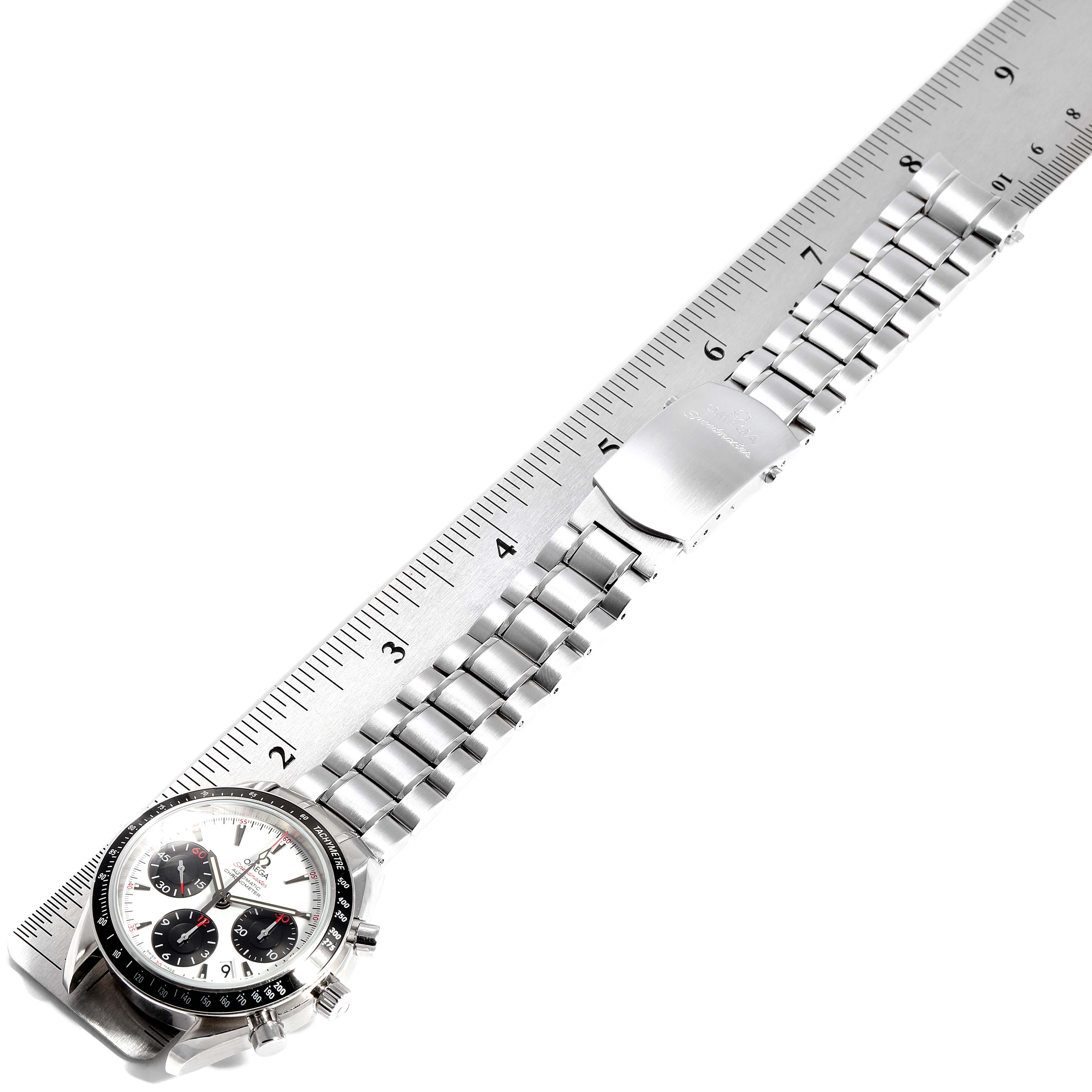 The image shows an Omega Speedmaster 323.30.40.40.04.001 Men's Stainless Steel White Dial 323.30.40.40.04.001 Men's Stainless Steel White Dial watch laid flat against a ruler, displaying its face and metal bracelet.