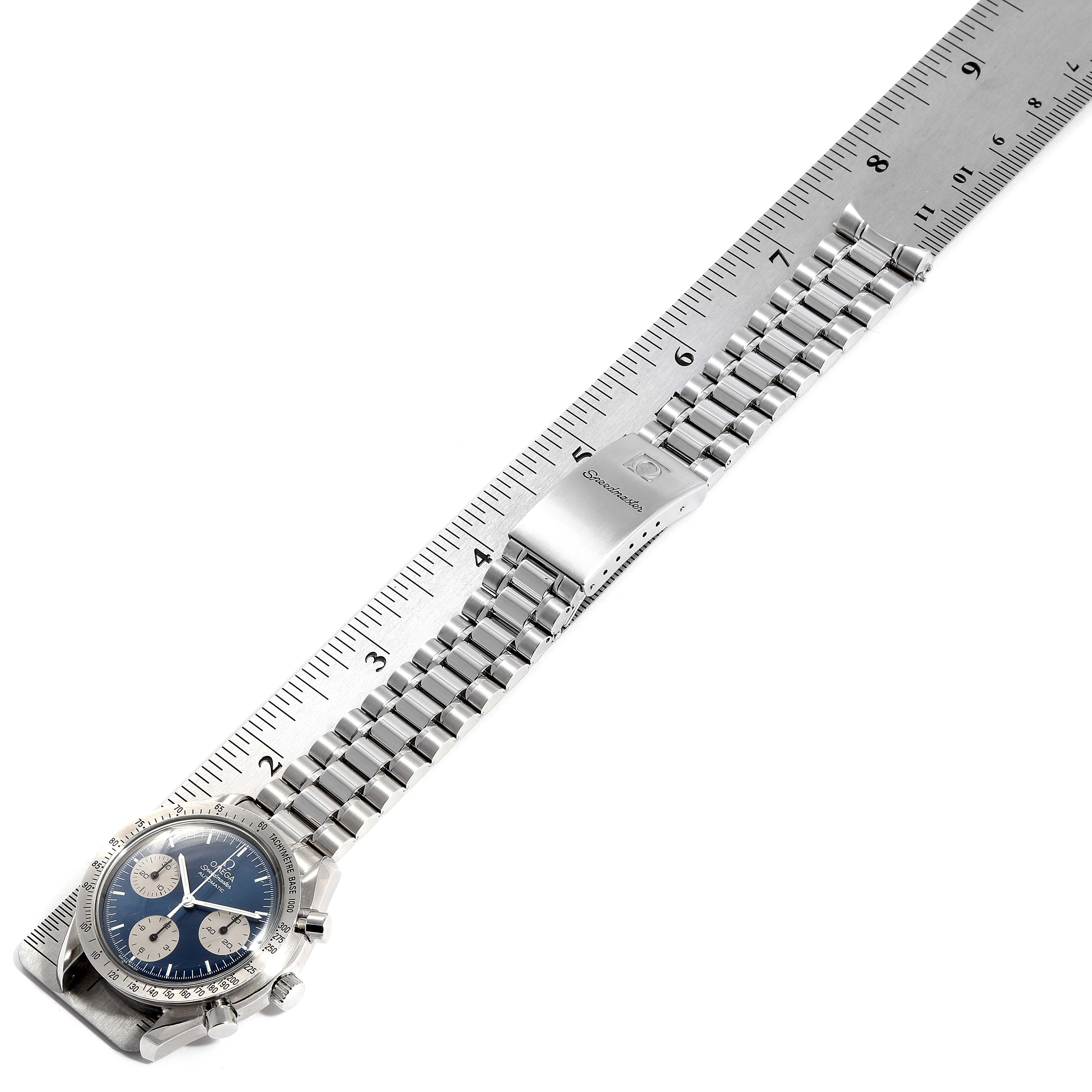 This image shows an Omega Speedmaster 3510.82.00 Men
s Stainless Steel Blue Dial 3510.82.00 Men
s Stainless Steel Blue Dial watch laid flat next to a ruler, highlighting its face, bracelet, and clasp.