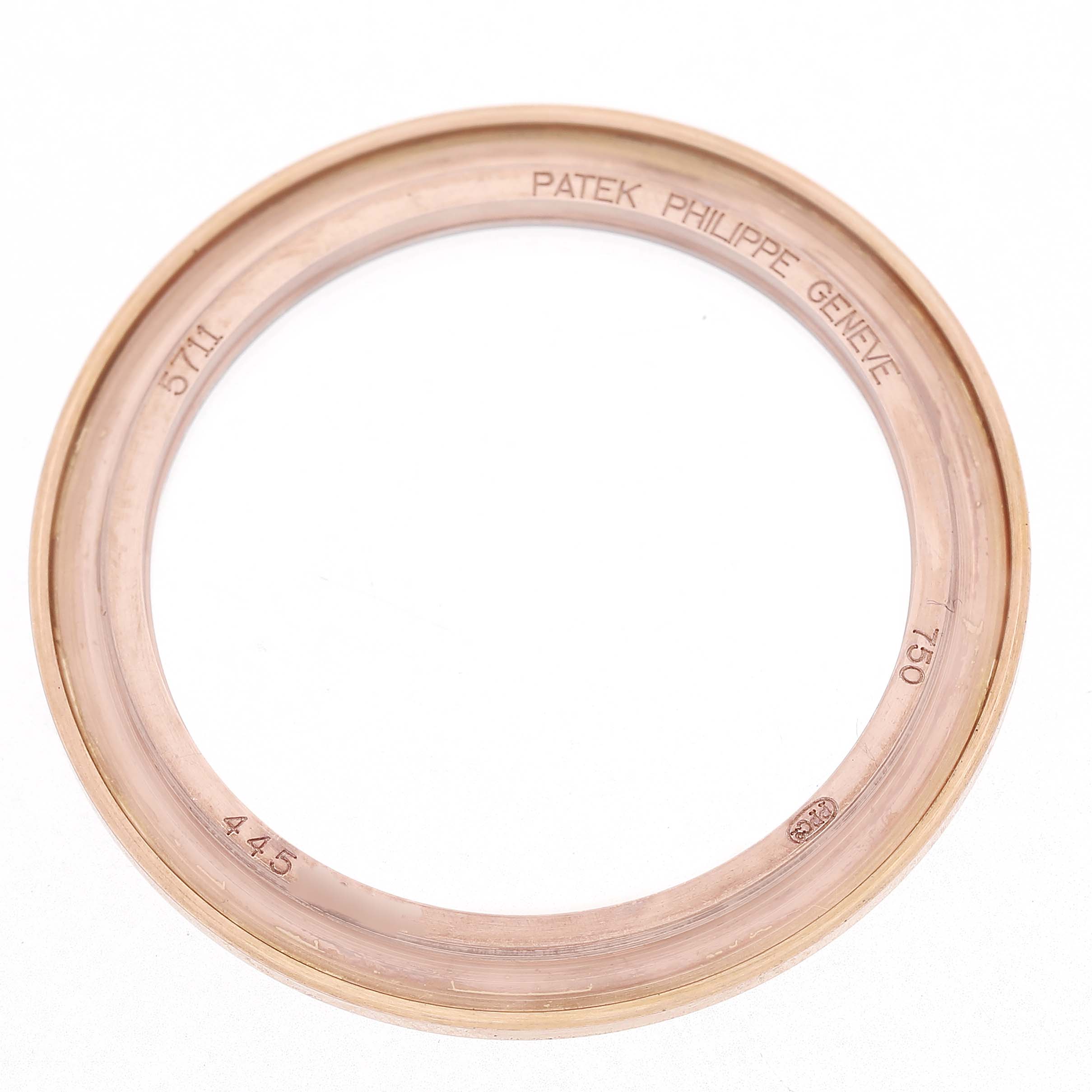The image shows the bezel of a Patek Philippe Nautilus 5711R-001 Men's Rose Gold Grey Dial watch, viewed from above, with engravings on the inner surface.