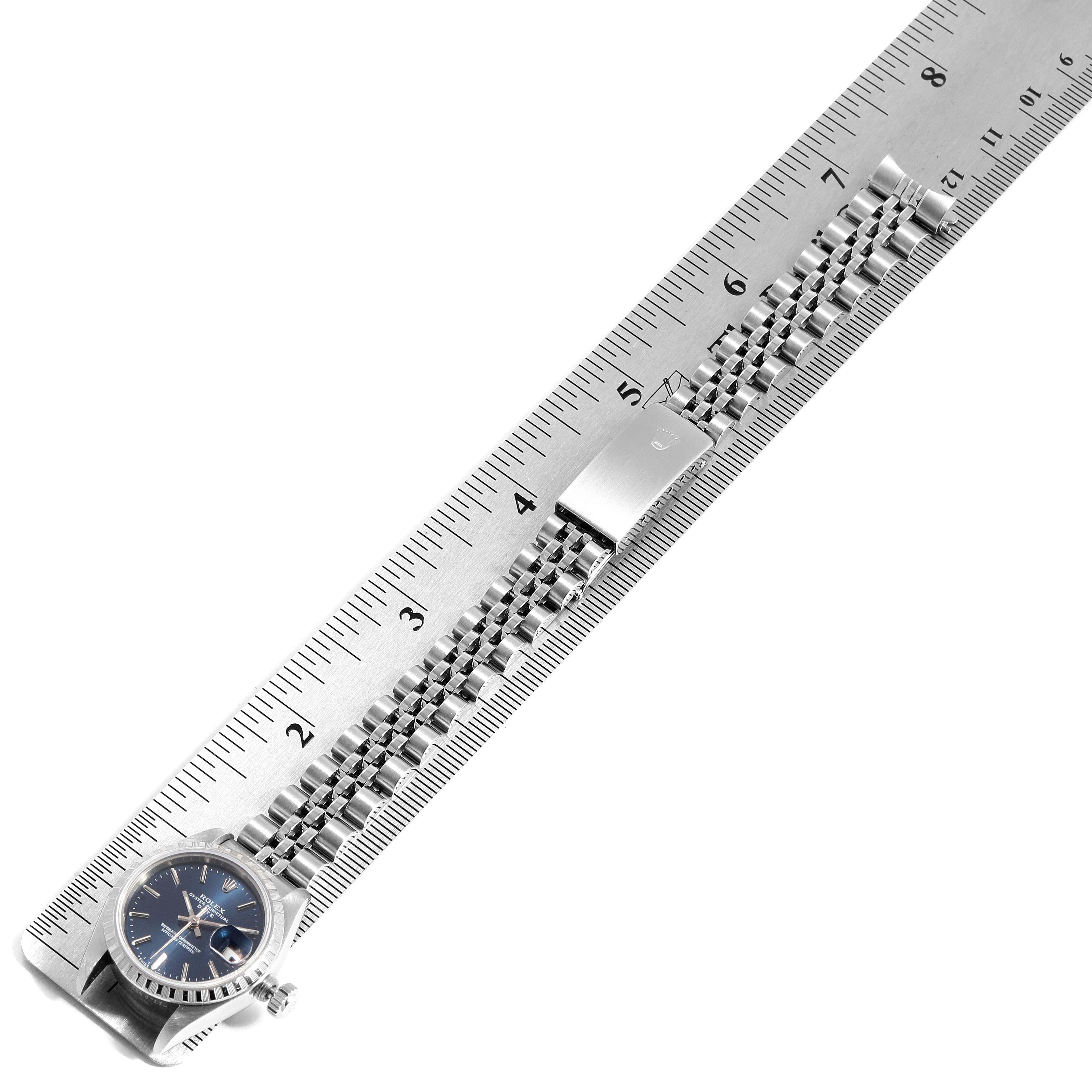 The image shows the bracelet and face of a Rolex Datejust 69240  Women's Stainless Steel Blue Dial 69240  Women's Stainless Steel Blue Dial watch, laid out on a ruler for measurement.