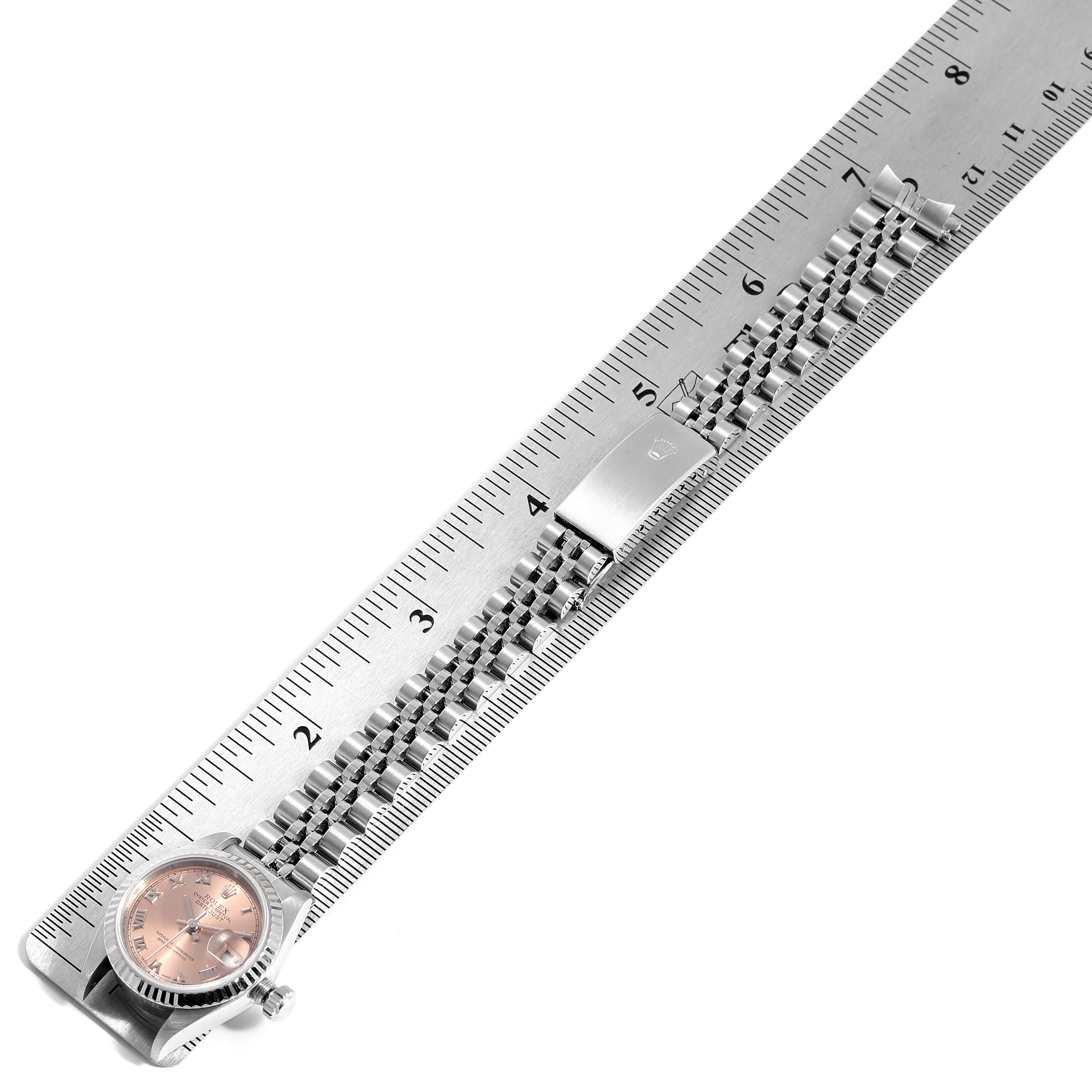 The image shows a Rolex Datejust 79174 Women's Stainless Steel Pink Dial 79174 Women's Stainless Steel Pink Dial watch laid flat next to a ruler, displaying the watch face, bracelet, and clasp.