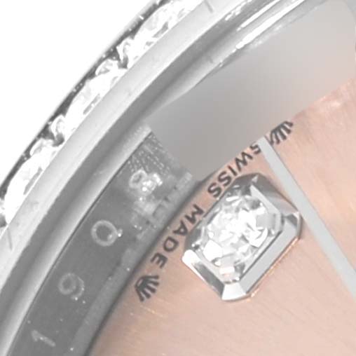The image shows a close-up of a Rolex Datejust 279384 Women's Stainless Steel Pink Dial 279384 Women's Stainless Steel Pink Dial watch's bezel, dial, and a diamond hour marker.
