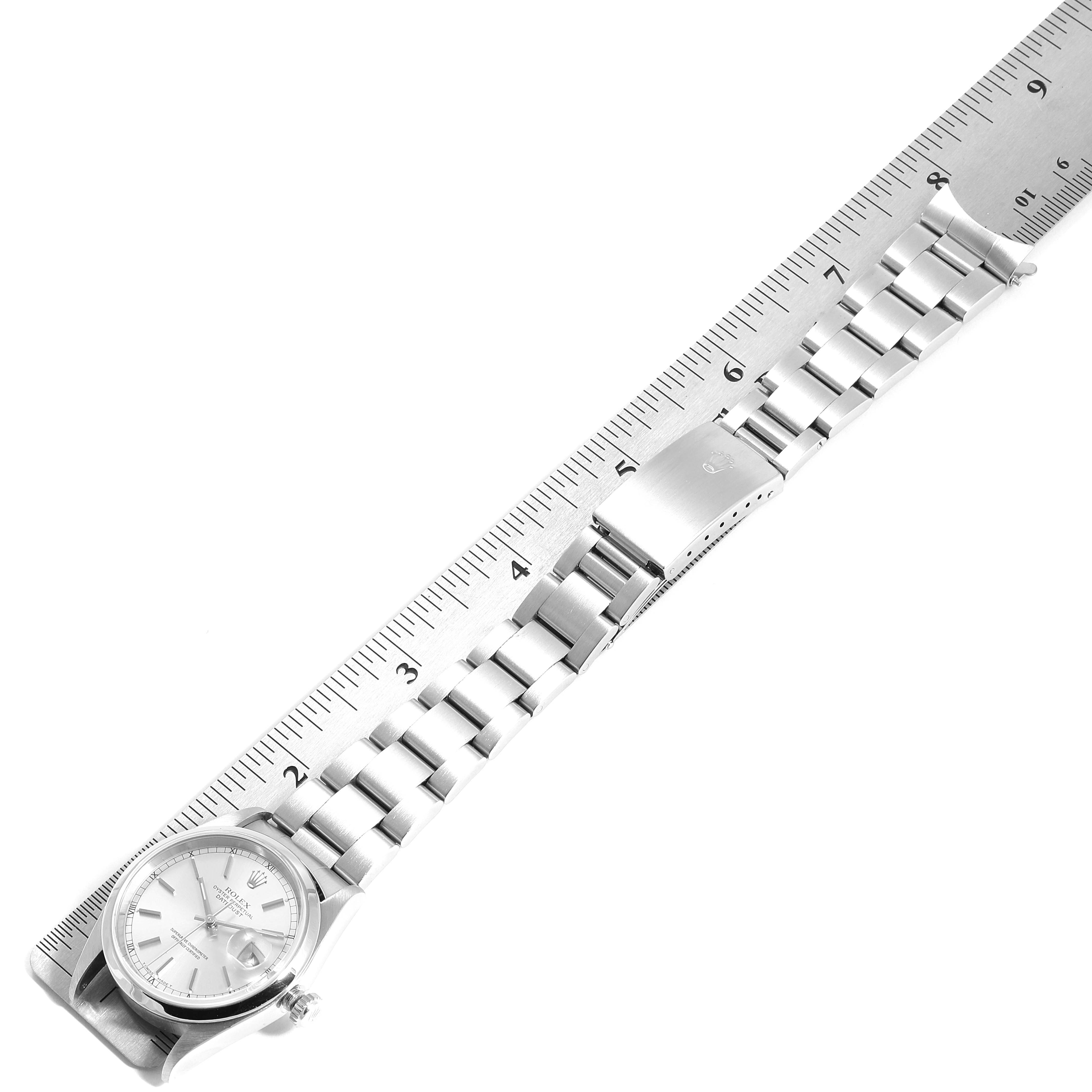 The image shows the Rolex Datejust 16200 Men's Stainless Steel Silver Dial 16200 Men's Stainless Steel Silver Dial watch laying flat with its entire band measured by a ruler.