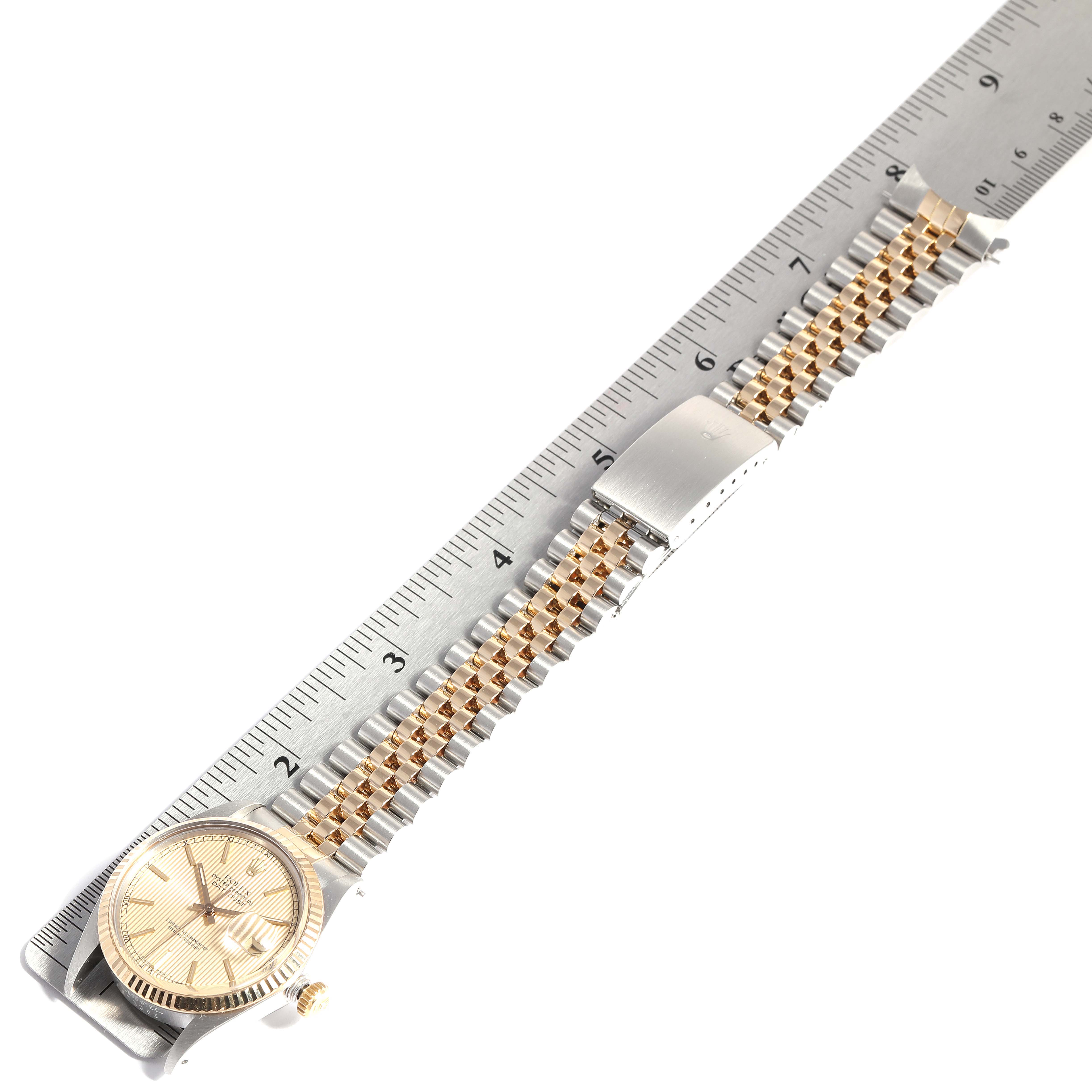 The image shows a Rolex Datejust 16013 Men's Steel and Gold (two tone) Champagne Dial 16013 Men's Steel and Gold (two tone) Champagne Dial watch from an overhead angle, highlighting its bezel, dial, and metal bracelet alongside a ruler for scale.