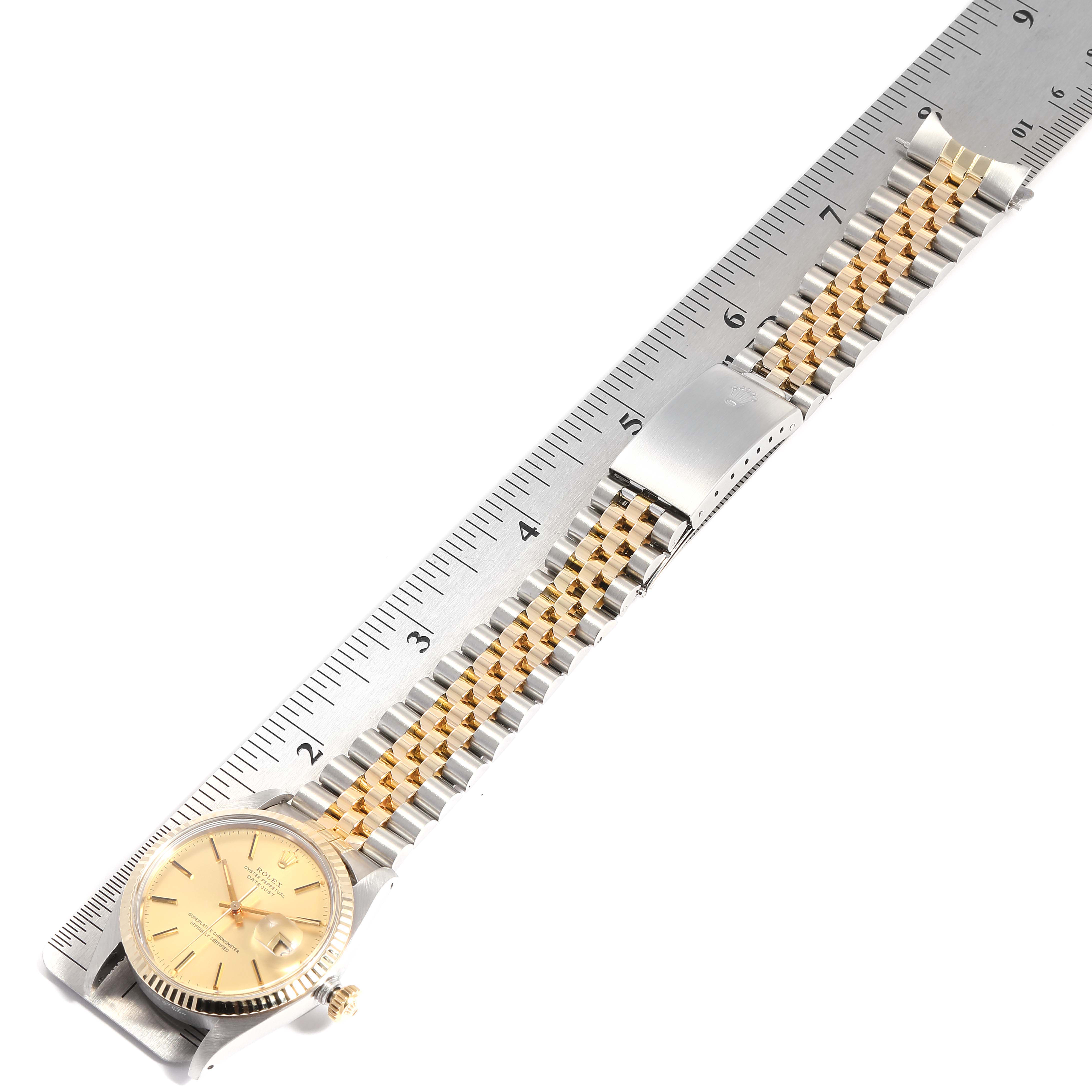 The image shows a top view of a Rolex Vintage Collection 16013 Men
s Steel and Gold (two tone) Champagne Dial 16013 Men
s Steel and Gold (two tone) Champagne Dial watch, including the face, crown, and entire bracelet next to a ruler.