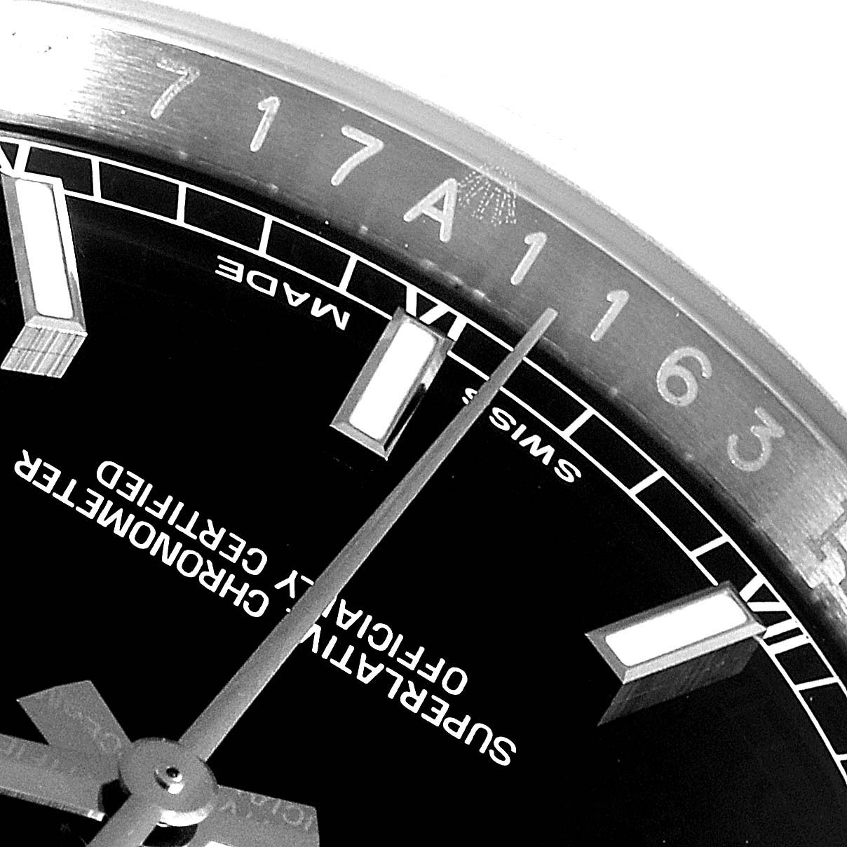 The image shows a close-up of the Rolex Datejust 116200  Men's Stainless Steel Black Dial 116200  Men's Stainless Steel Black Dial watch dial and partially the rehaut with engraved markings.