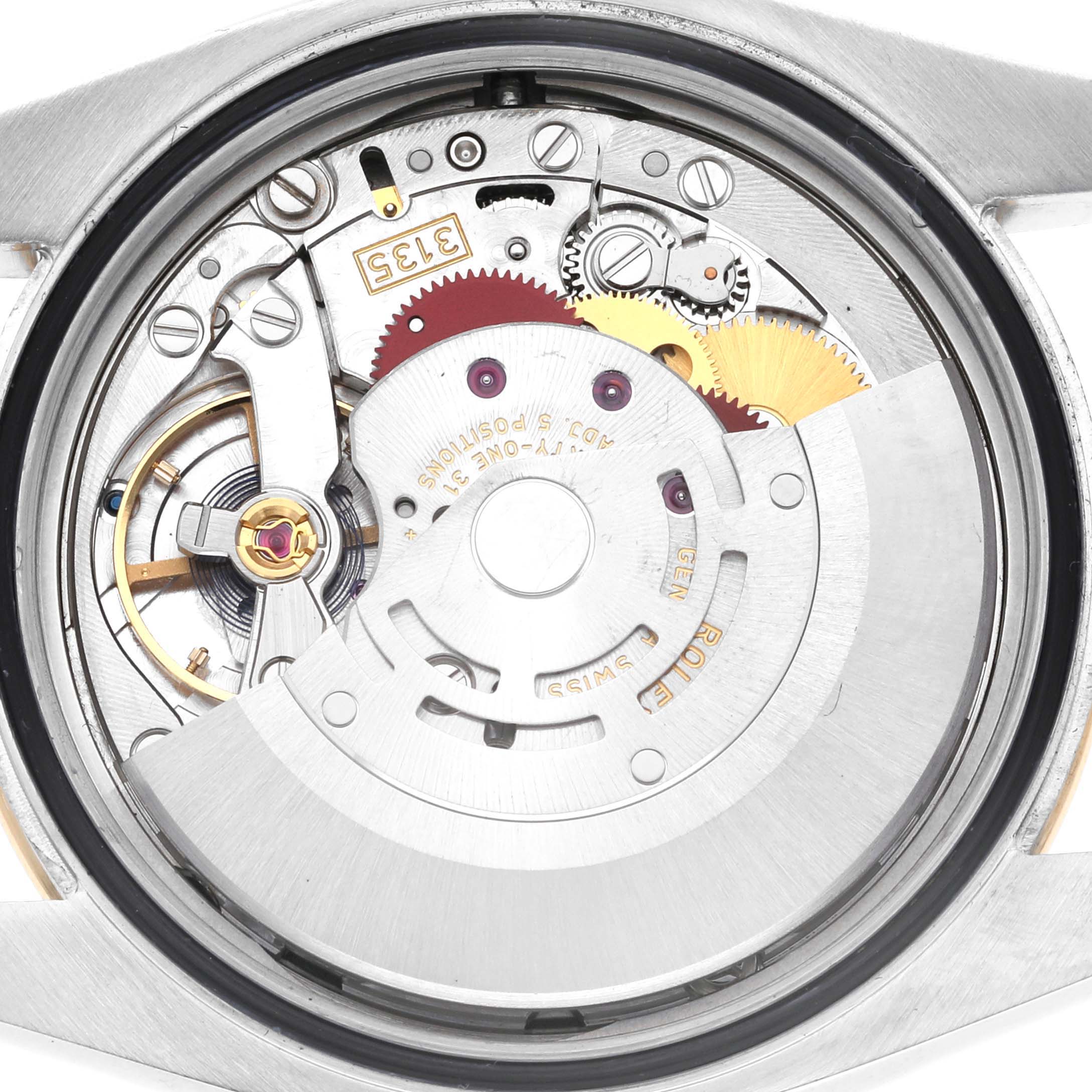 The image shows the movement mechanism of a Rolex Datejust 116243 Men's Steel and Gold (two tone) Black Dial 116243 Men's Steel and Gold (two tone) Black Dial watch viewed from the back, displaying various gears and components.