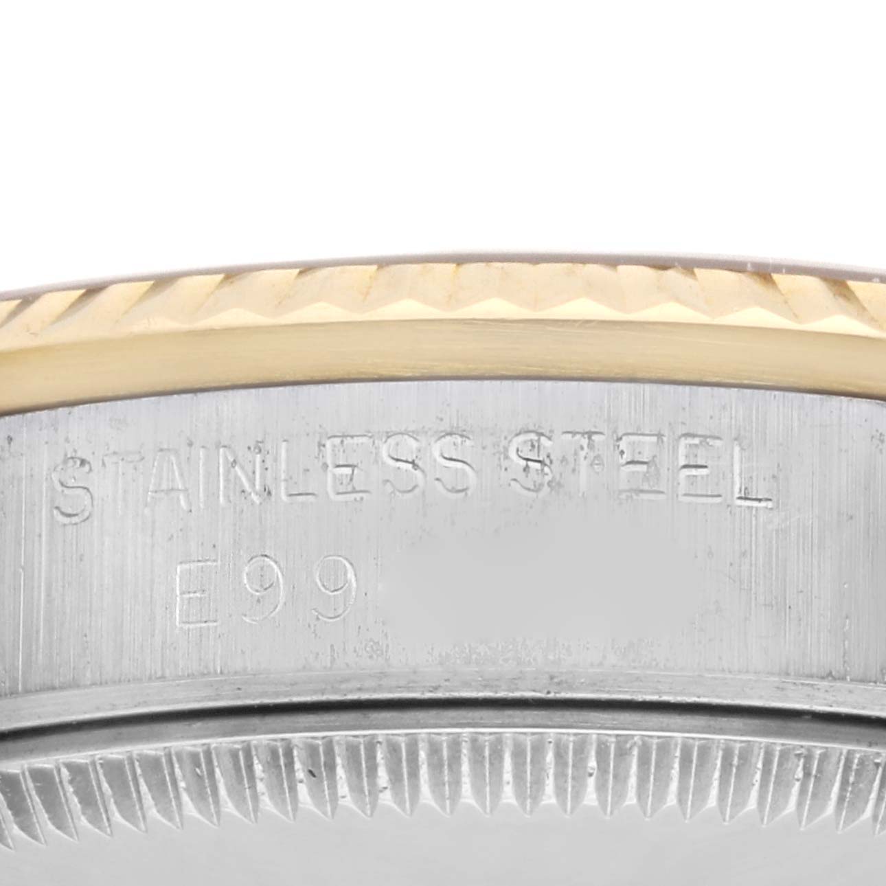 Close-up of the bezel and stainless steel back case of a mid-size Rolex watch.